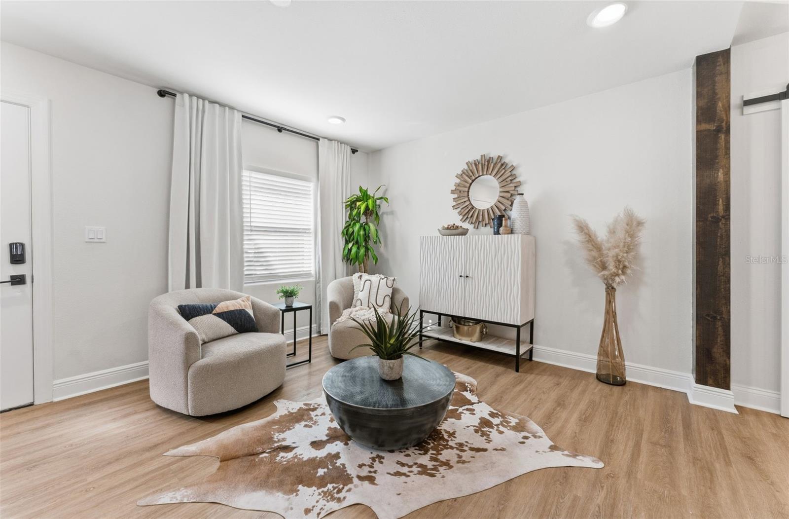 Small seating area to the left of the entry framed by a large window.
