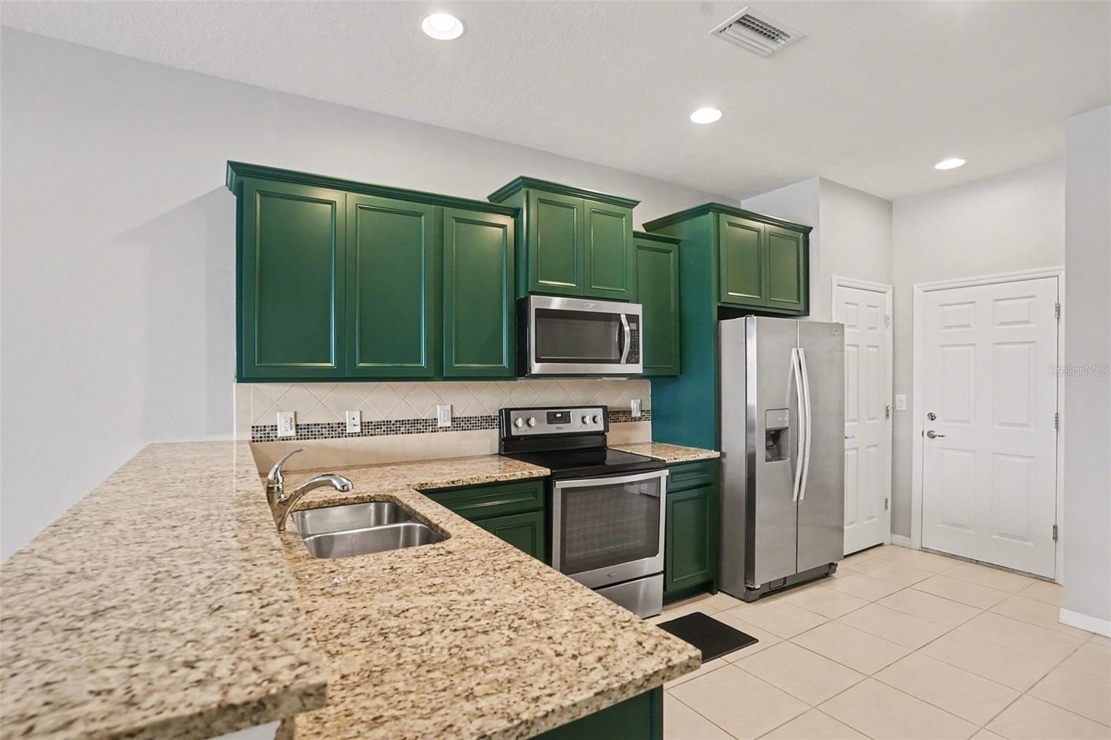 Kitchen complete with pantry and door that leads to the garage
