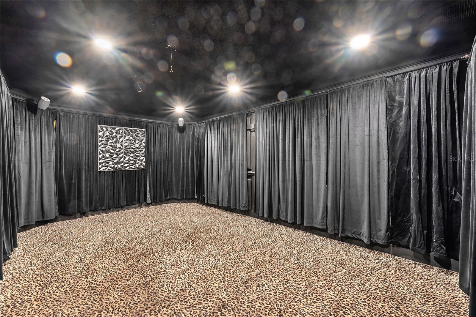 Your visitors will be jealous of this dedicated theater room featuring sound-proofed walls and built-in speakers. Finished in black with acoustic foam and velvet curtains, the space fully immerses you in a true cinematic experience.