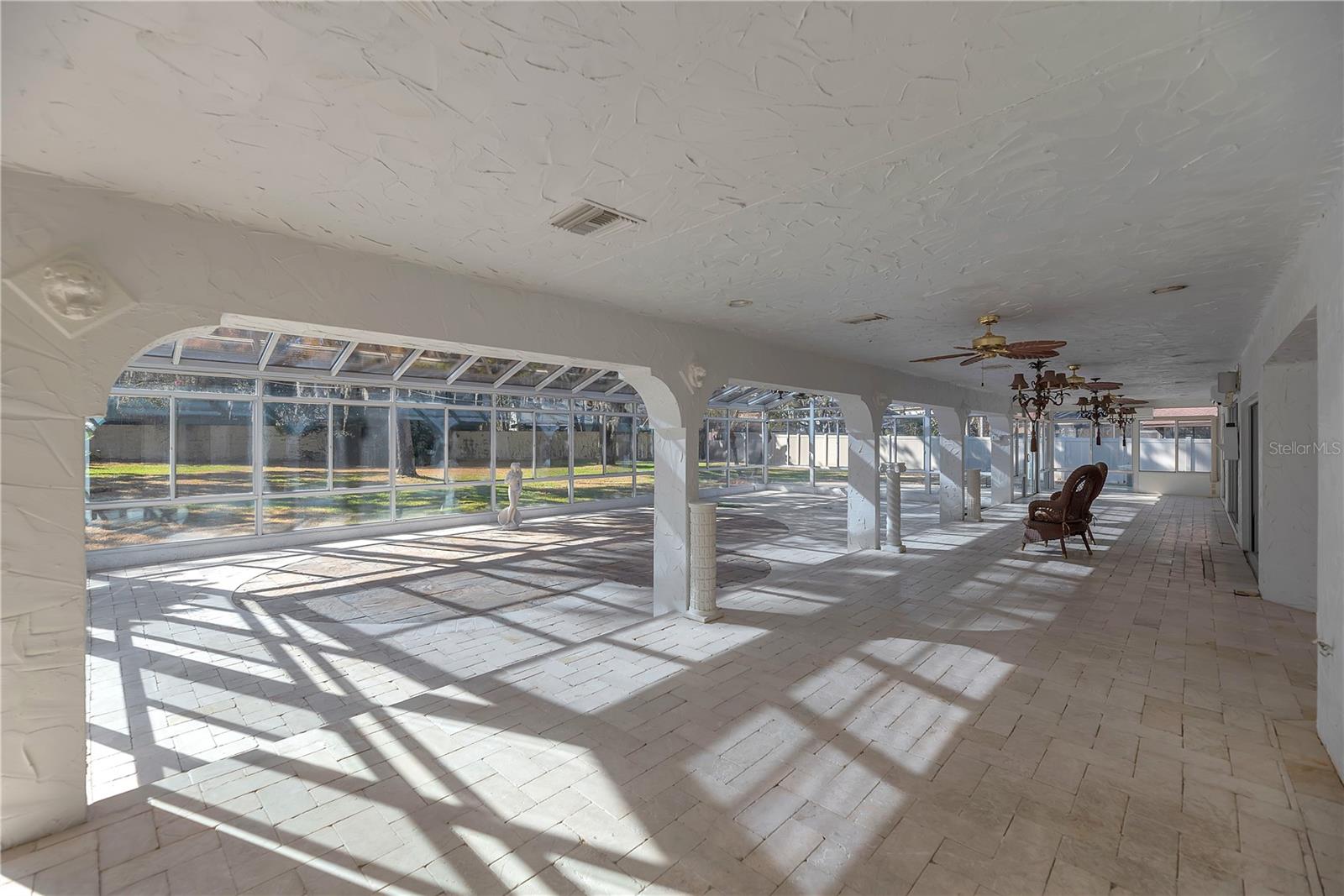 Finished with marble pavers this former screened lania has been transformed into a large 4 season multi-purpose room.