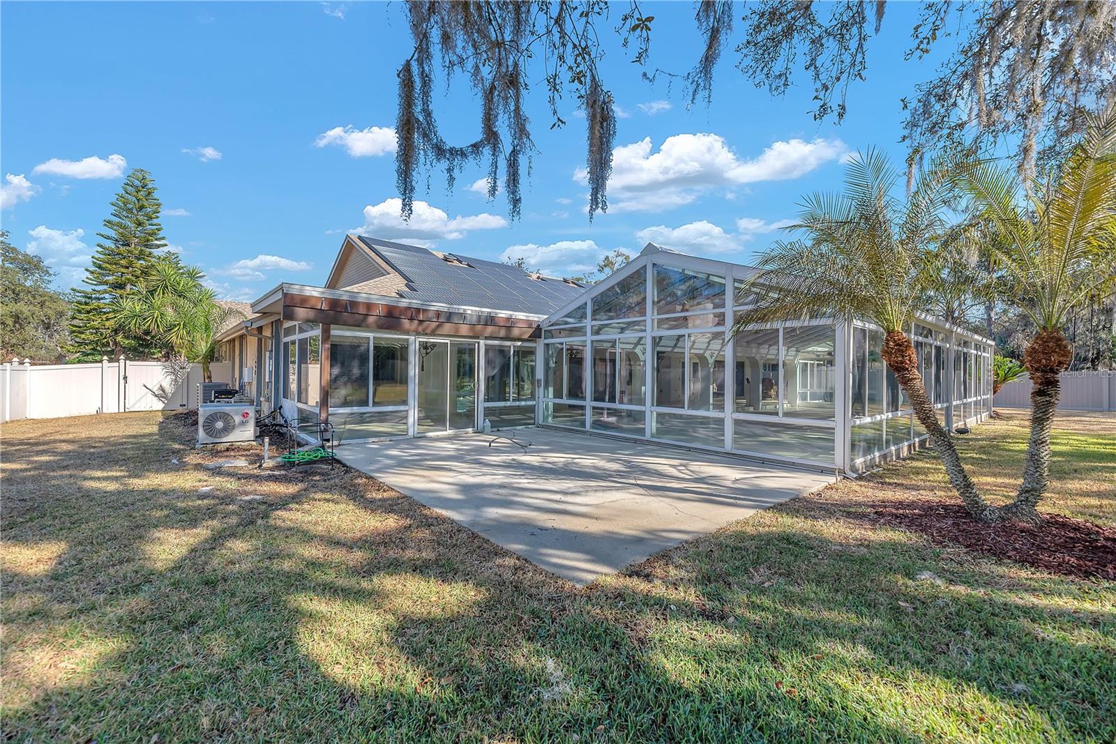 Patio outside of atrium and view of side yard with gate access to the front.