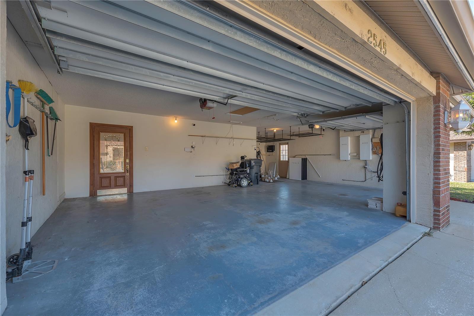 This oversized 3-car garage has two Tesla EV charging stations, overhead storage racks, and the home’s solar power center—designed to eliminate monthly electric bills.