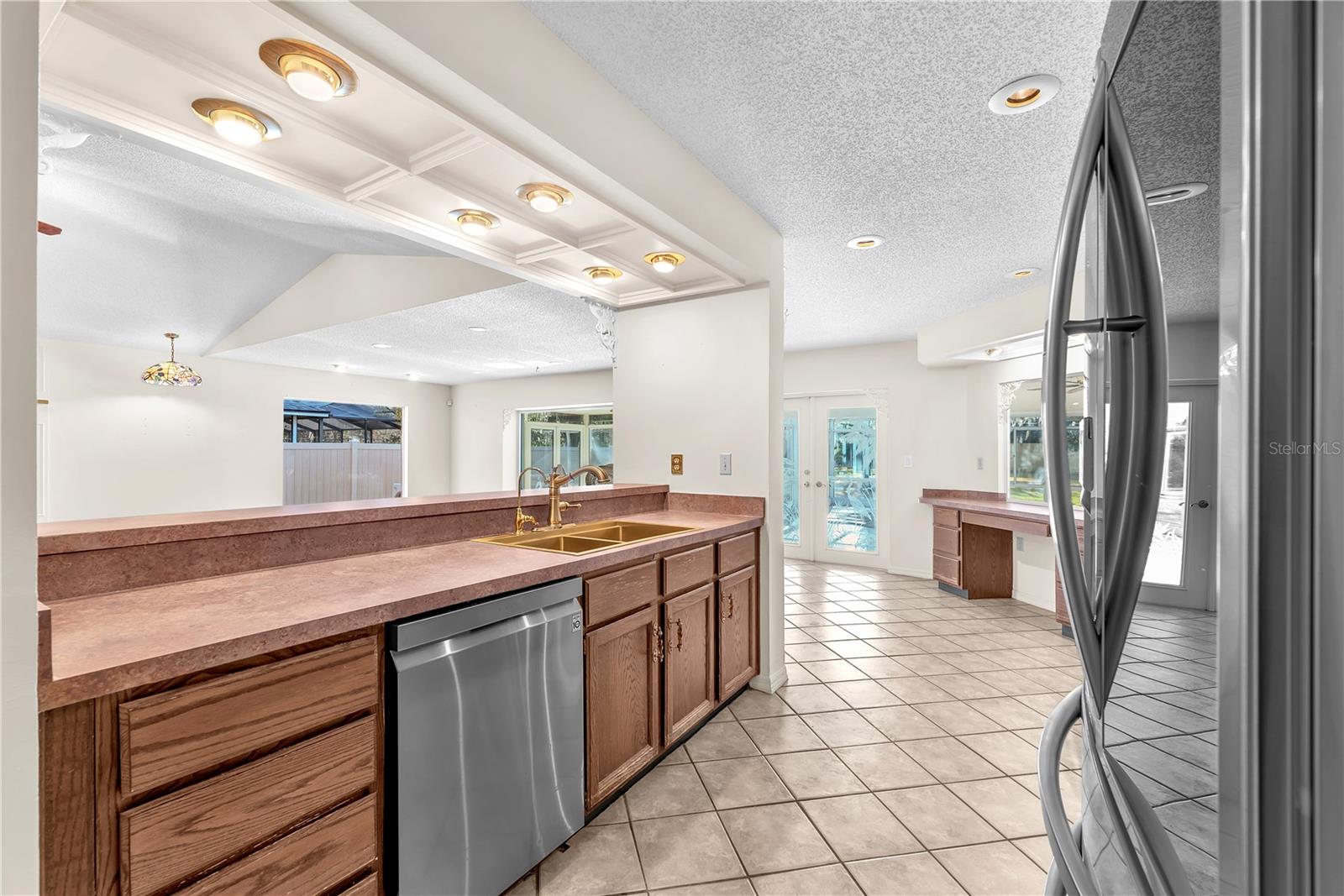 The heart of the home is the chef-inspired kitchen, boasting expansive countertop space, stainless steel appliances, designer backsplash, brass double-basin sink in the breakfast bar, eat-in nook, and a built-in desk area.