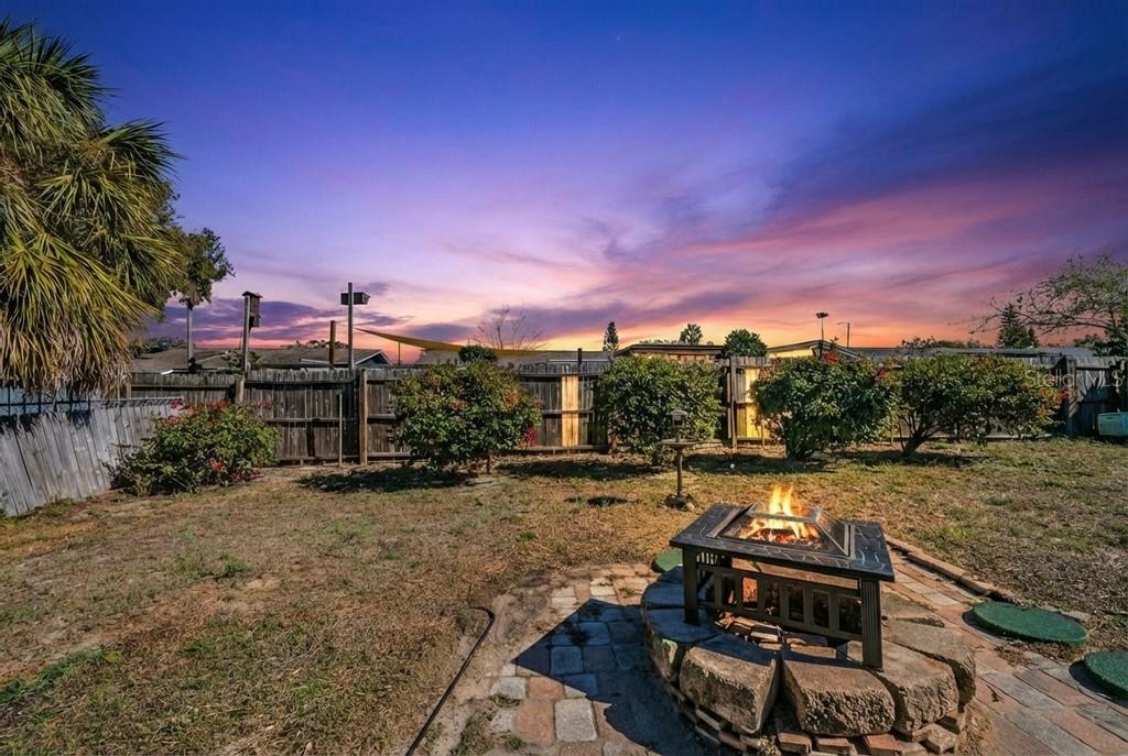 Fenced in back yard with fire pit, and back screened and covered patio.