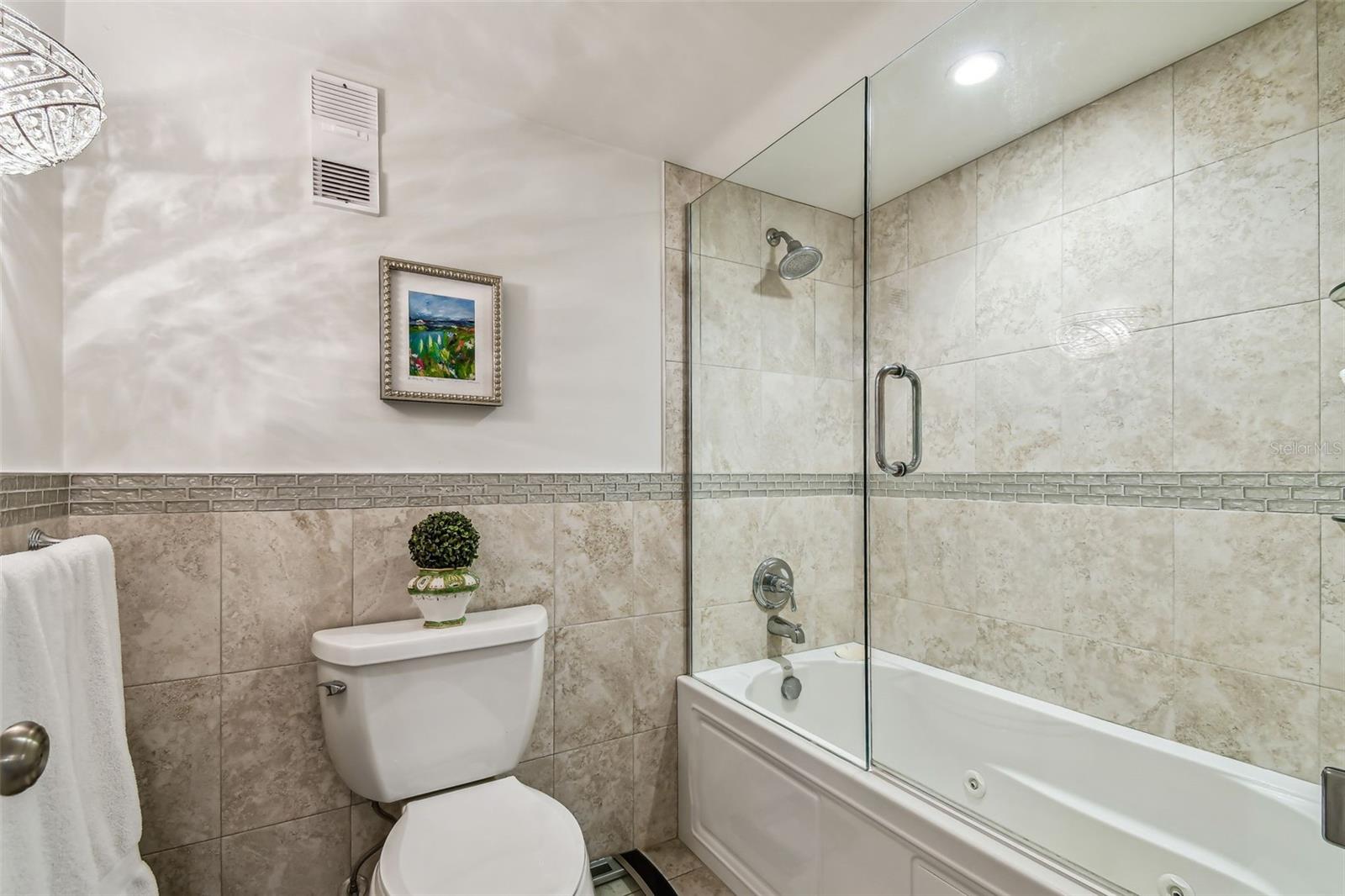 Primary bathroom with double vanity, large walk-in closet and tub