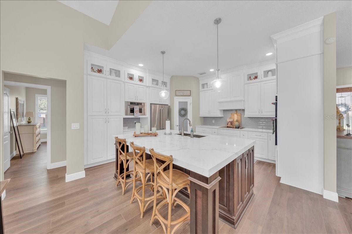 Chef's kitchen with oversized island, floor-to-ceiling cabinetry, and sleek pendant lighting!