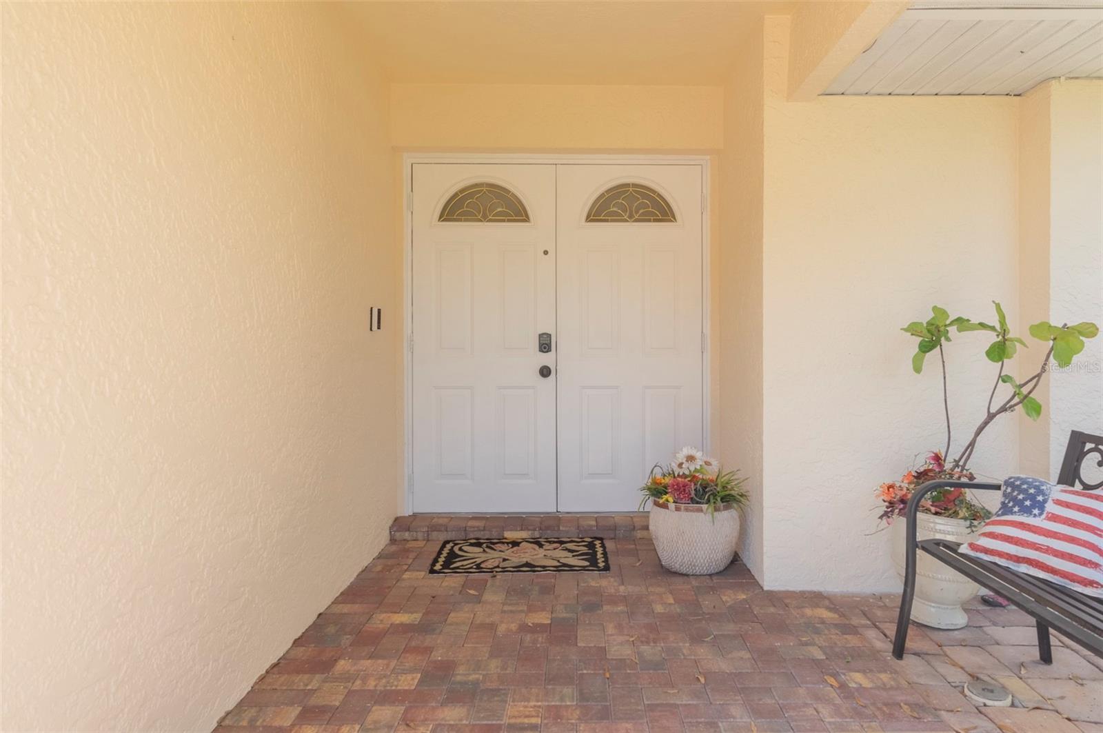COVERED FRONT PORCH WITH AND FEATURING A DOUBLE DOOR ENTRANCE.