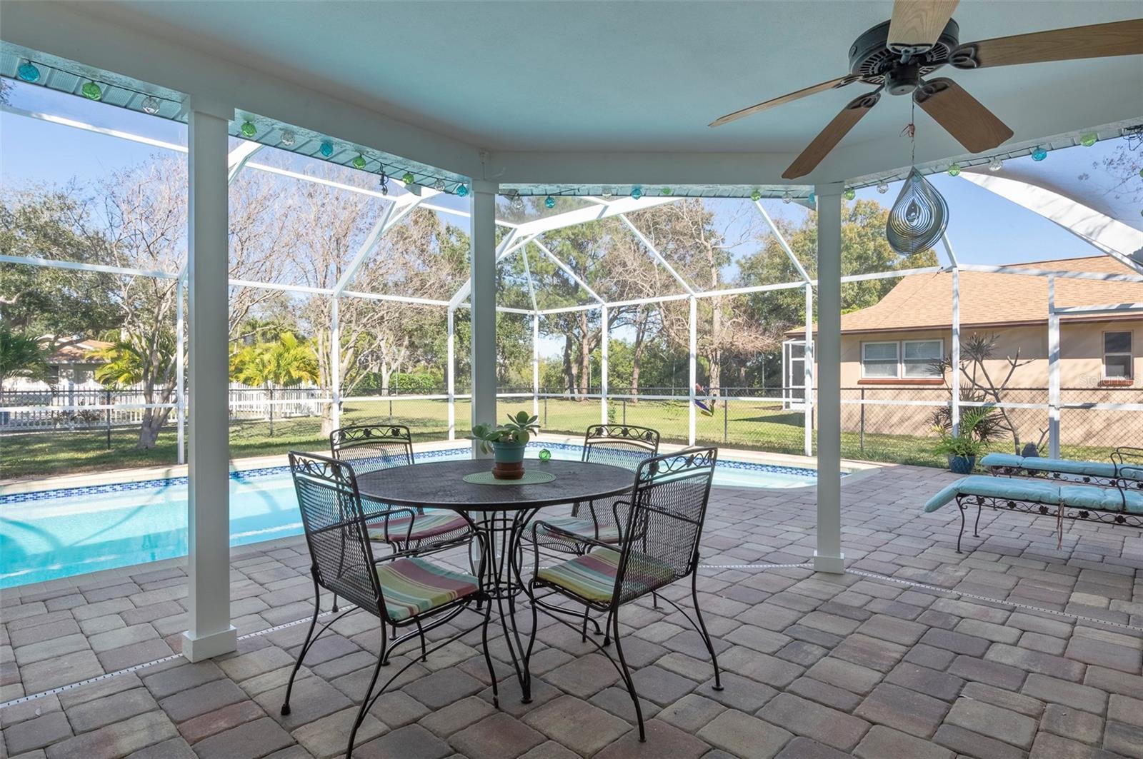 LARGE PATIO WITH PAVERS THAT IS UNER ROOF AND OVER LOOKS THE POOL