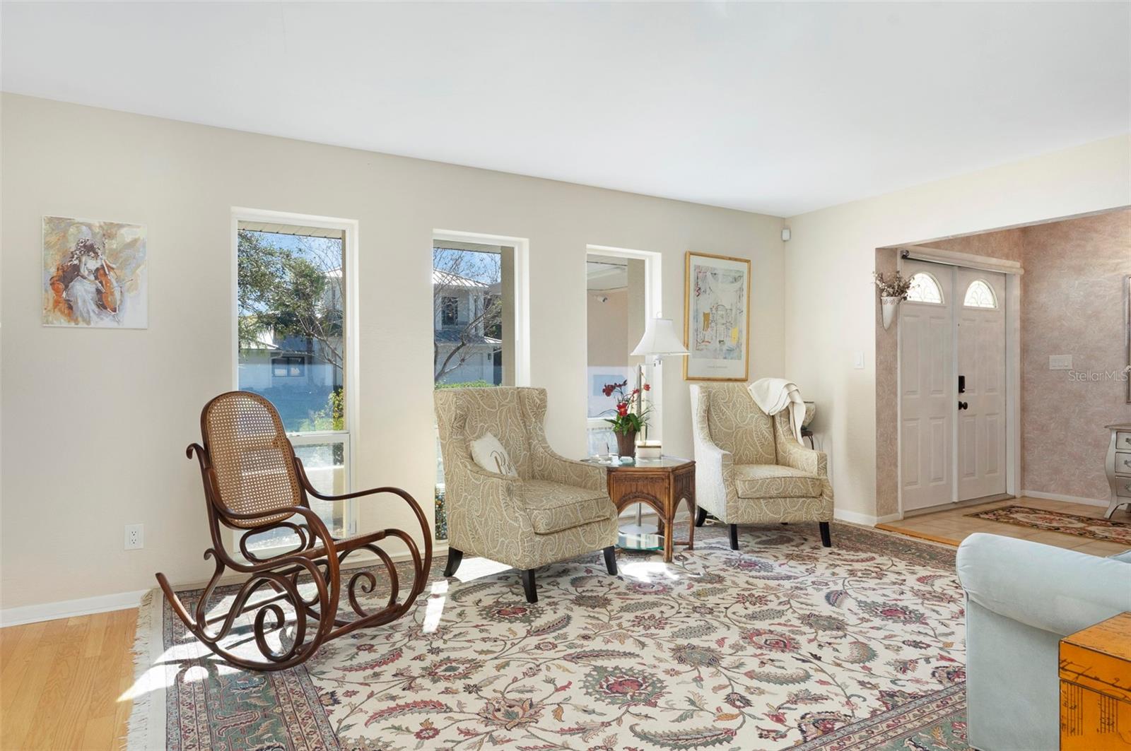 LIVING ROOM WITH LARGE WINDOWS THAT BRING IN ALL THE NATURAL LIGHTING YOU DESIRE.