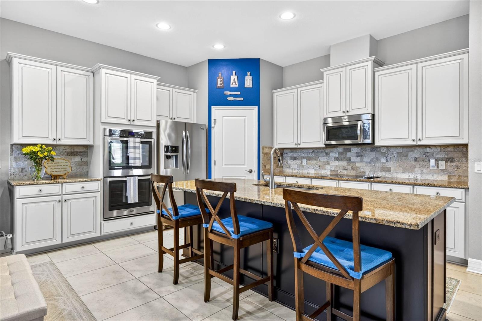 Kitchen with granite countertops, wood cabinetry, closet pantry.