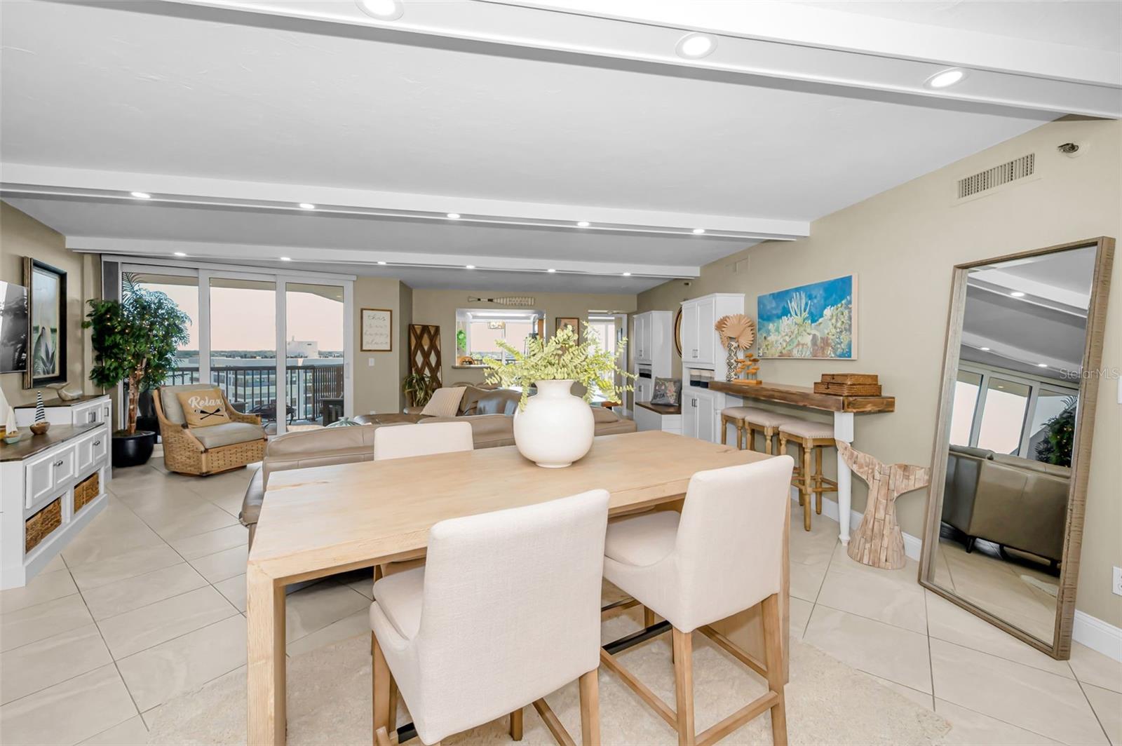 Elegant Living area with beamed ceilings with bright LED lighting recessed in the beams
