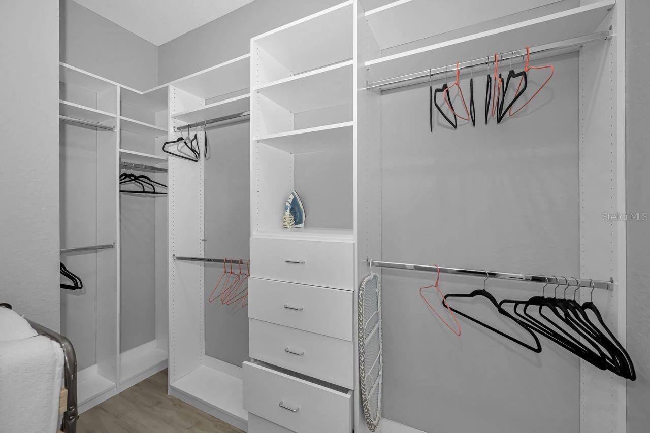 Primary walk-in closet with custom cabinetry