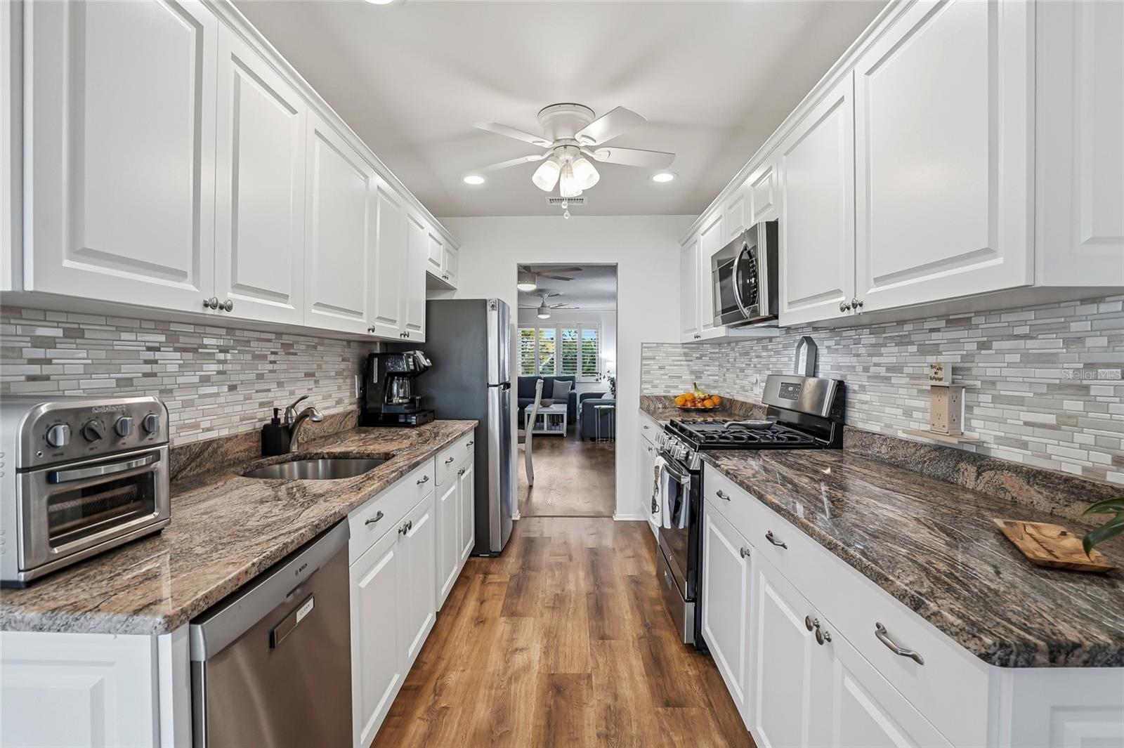Stunning and modern kitchen with custom cabinets, granite countertops and a gas range.