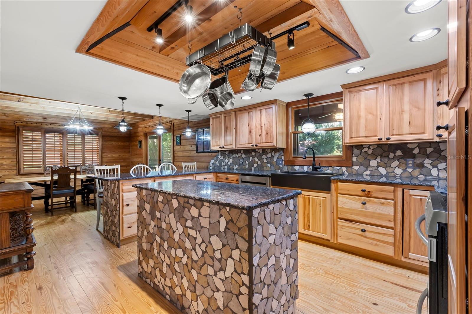 Kitchen lighting and ceiling details complement the exposed beam architecture, adding depth and warmth without distracting from the natural materials.