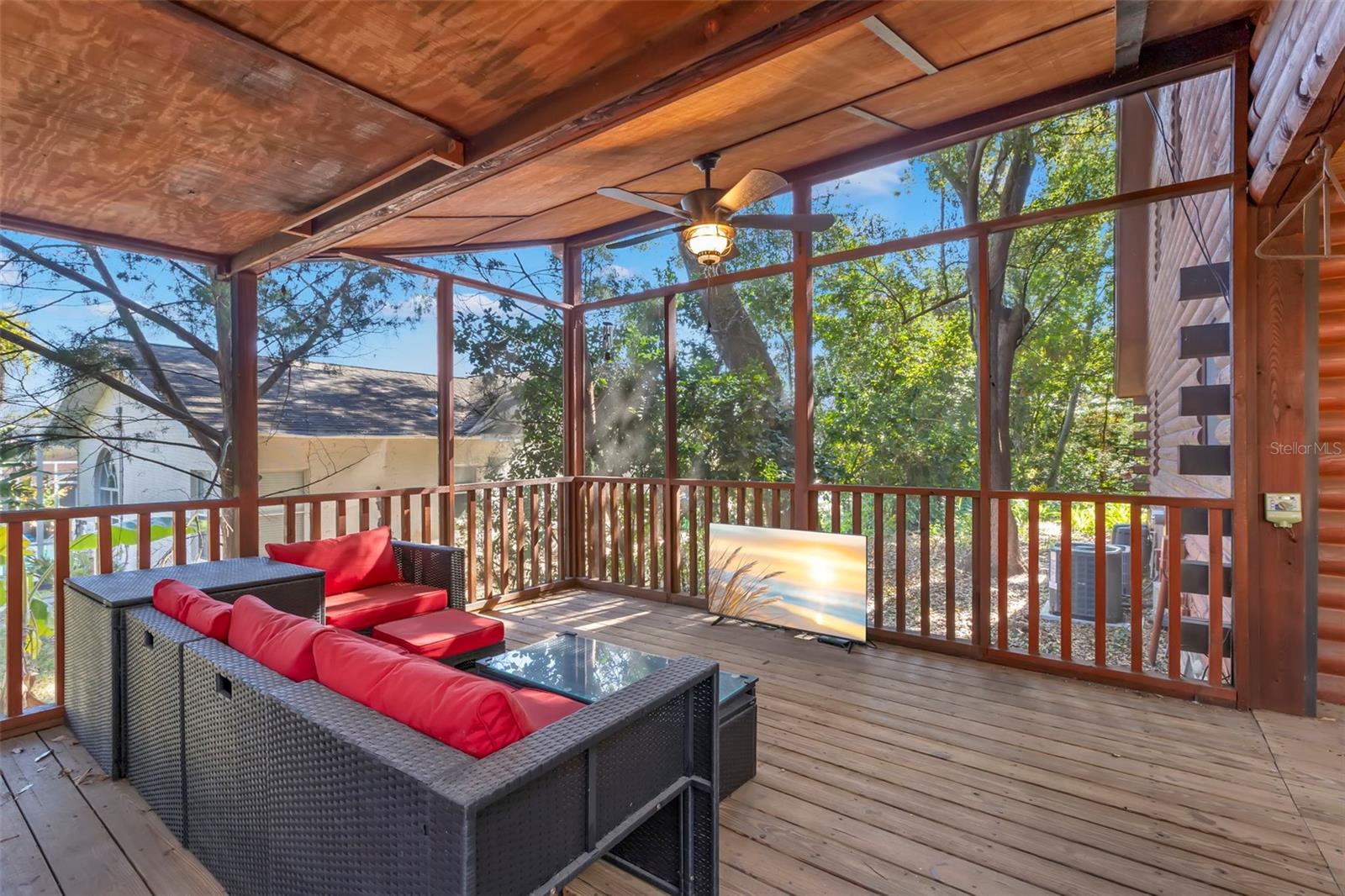 A beautifully proportioned screened-in porch that captures the feeling of a treehouse retreat, with warm wood tones, ceiling fans, and wide-open views of the surrounding landscape. Perfect for hosting guests or enjoying quiet moments in a natural setting.