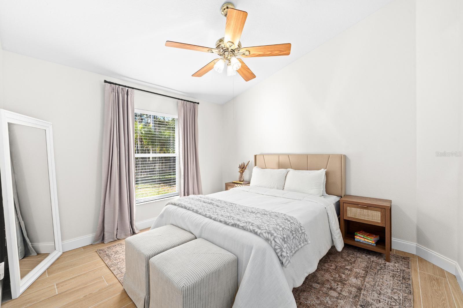 The second bedroom features the same plank tile flooring, a lighted ceiling fan, and a spacious closet!