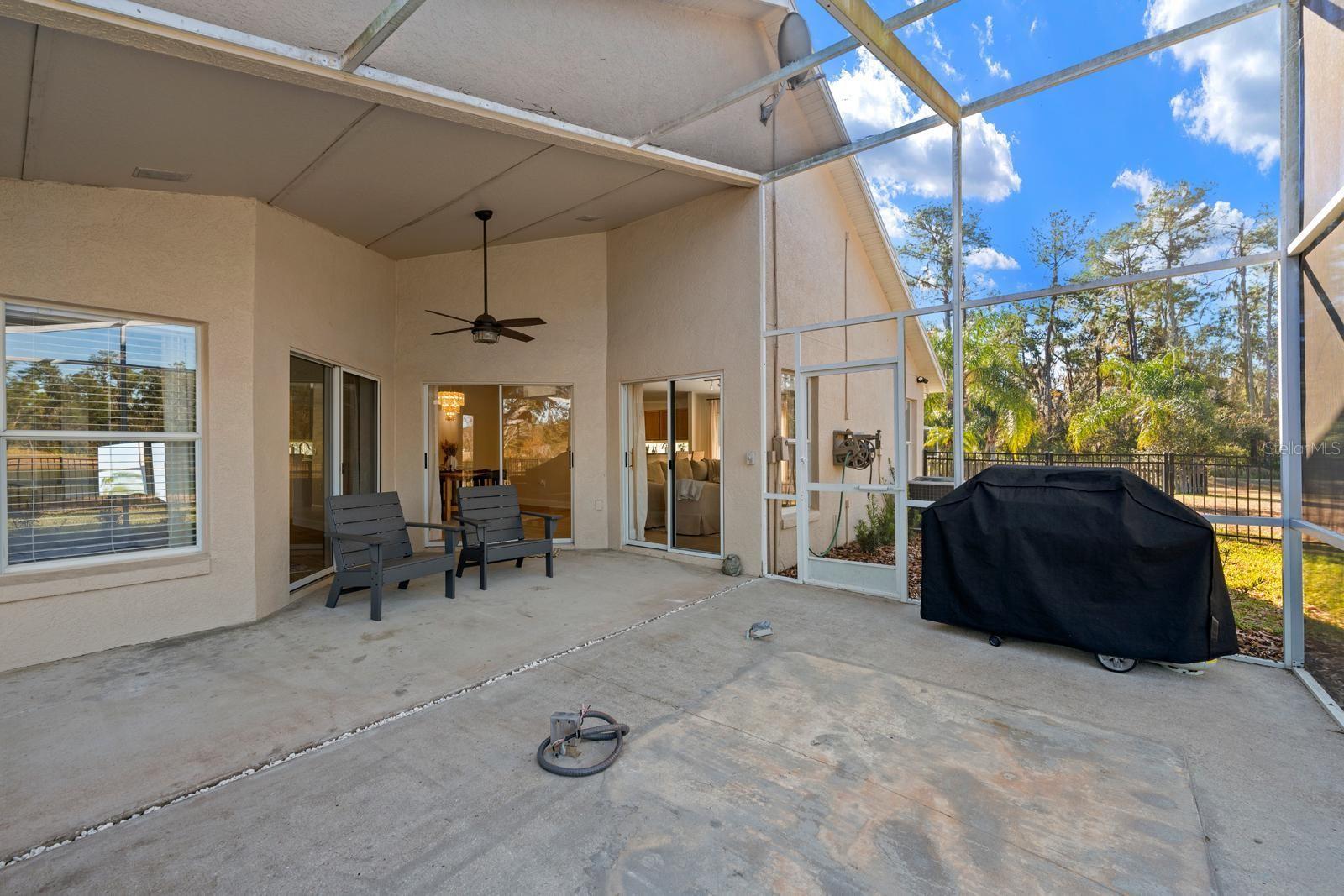 The screened-in porch is very large and has 2 screen doors and a ceiling fan.  There's a gas connection in the slab which can be utilized for a spa or an outdoor kitchen....or capped off and buried. There's also a narrow rock filled drain so rain water can drain properly.