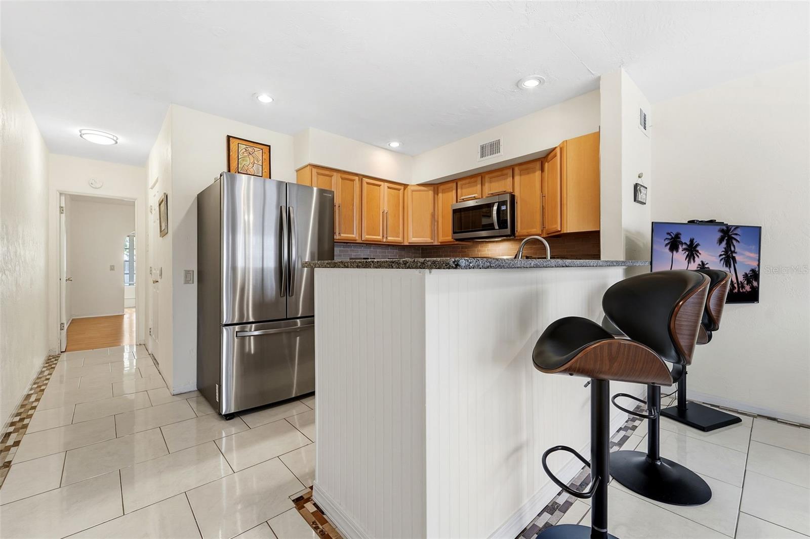 The kitchen features a counter-height dining area that blends function and style, ideal for both dining and entertaining.