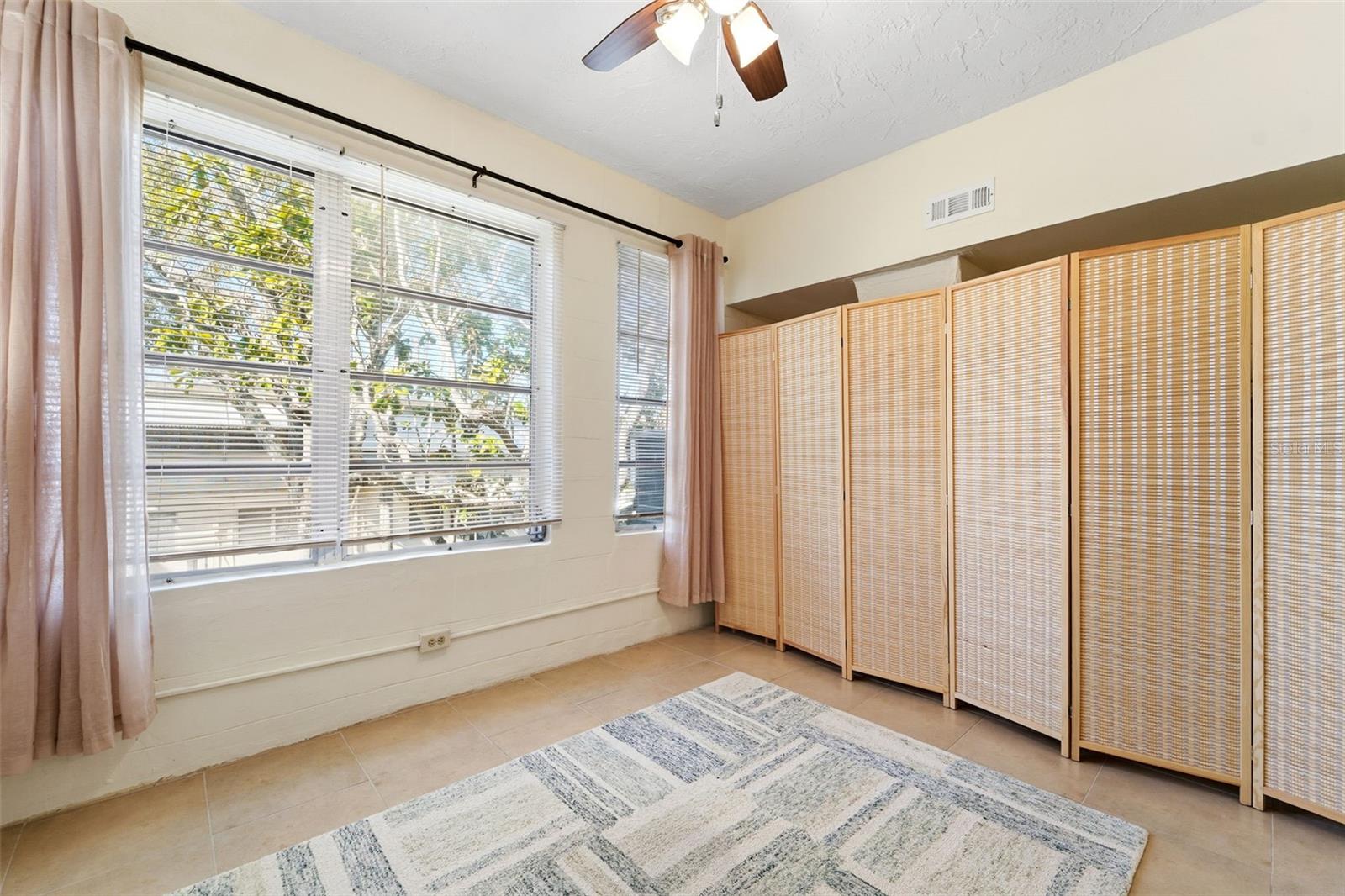 The Florida room enhances the home with versatile living space ideal for a TV room, hobby area, or home office, overlooking a lush, landscaped courtyard.