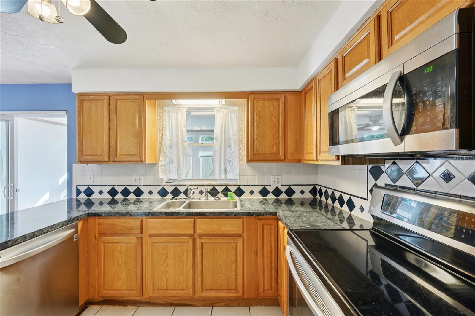 Kitchen with stainless steel appliances, granite countertops, pantry and window over sink