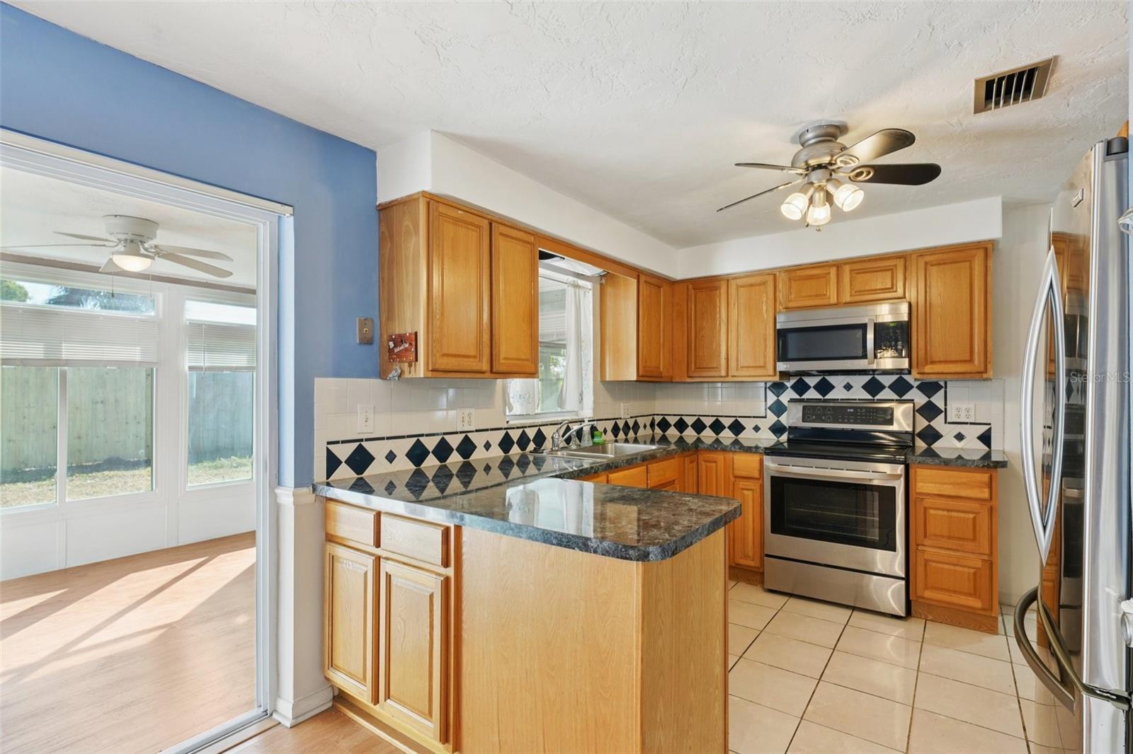 Kitchen with stainless steel appliances, granite countertops, pantry and window over sink
