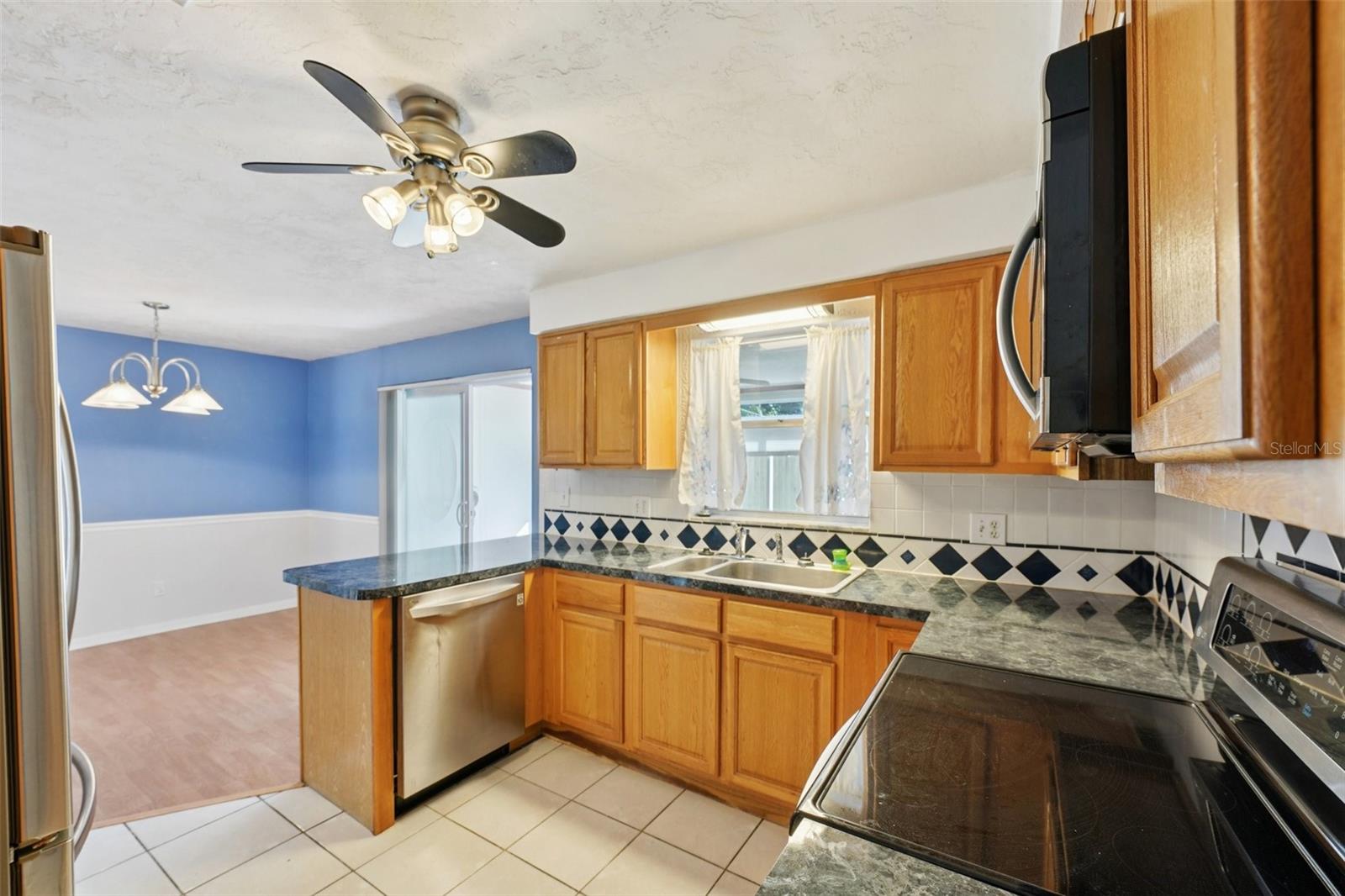 Kitchen with stainless steel appliances, granite countertops, pantry and window over sink