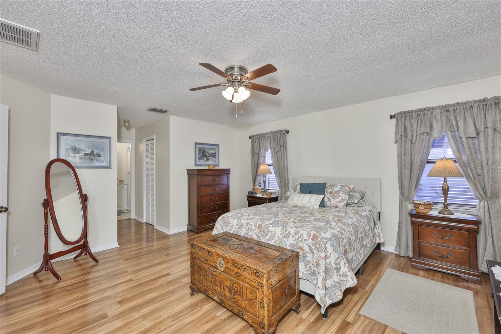 An oversized bedroom with walk in closet and large windows.