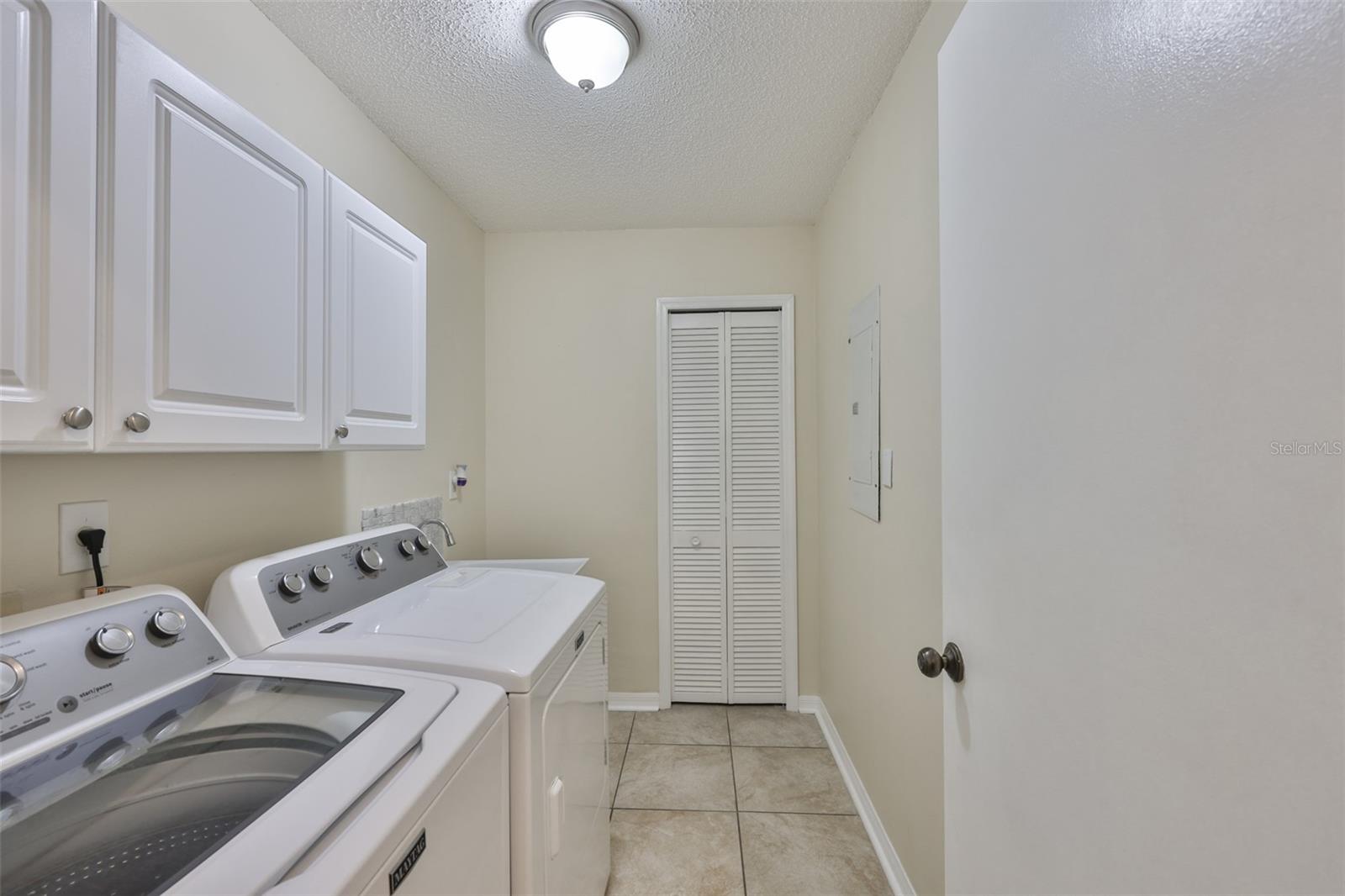 Laundry room is bright, with newer appliances, utility sink and pantry closet.