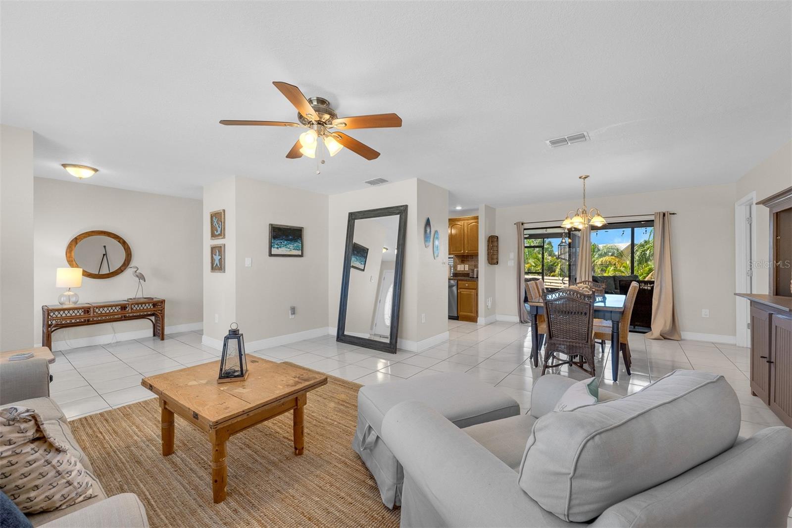Living Room looking into dining area and kitchen.  Great for entertaining.  Plenty of Natural Lighting.  Sliders out to screened lanai.