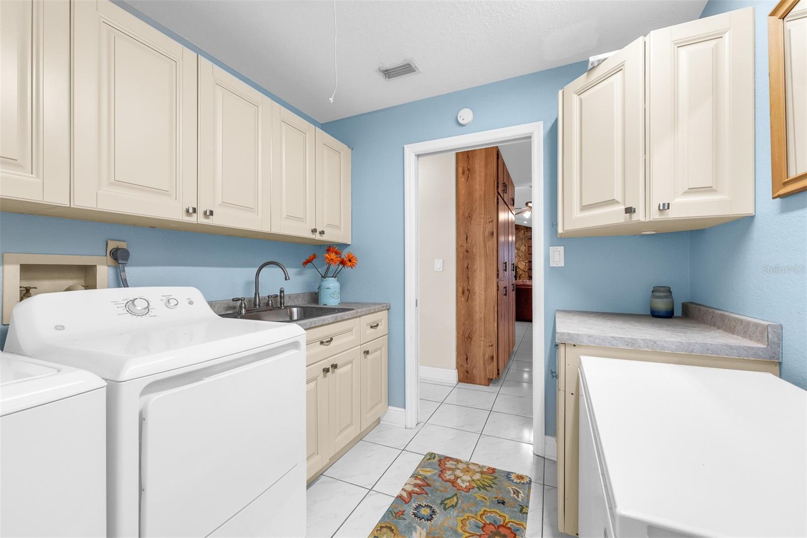 Laundry room with plenty of storage and sink and folding area.