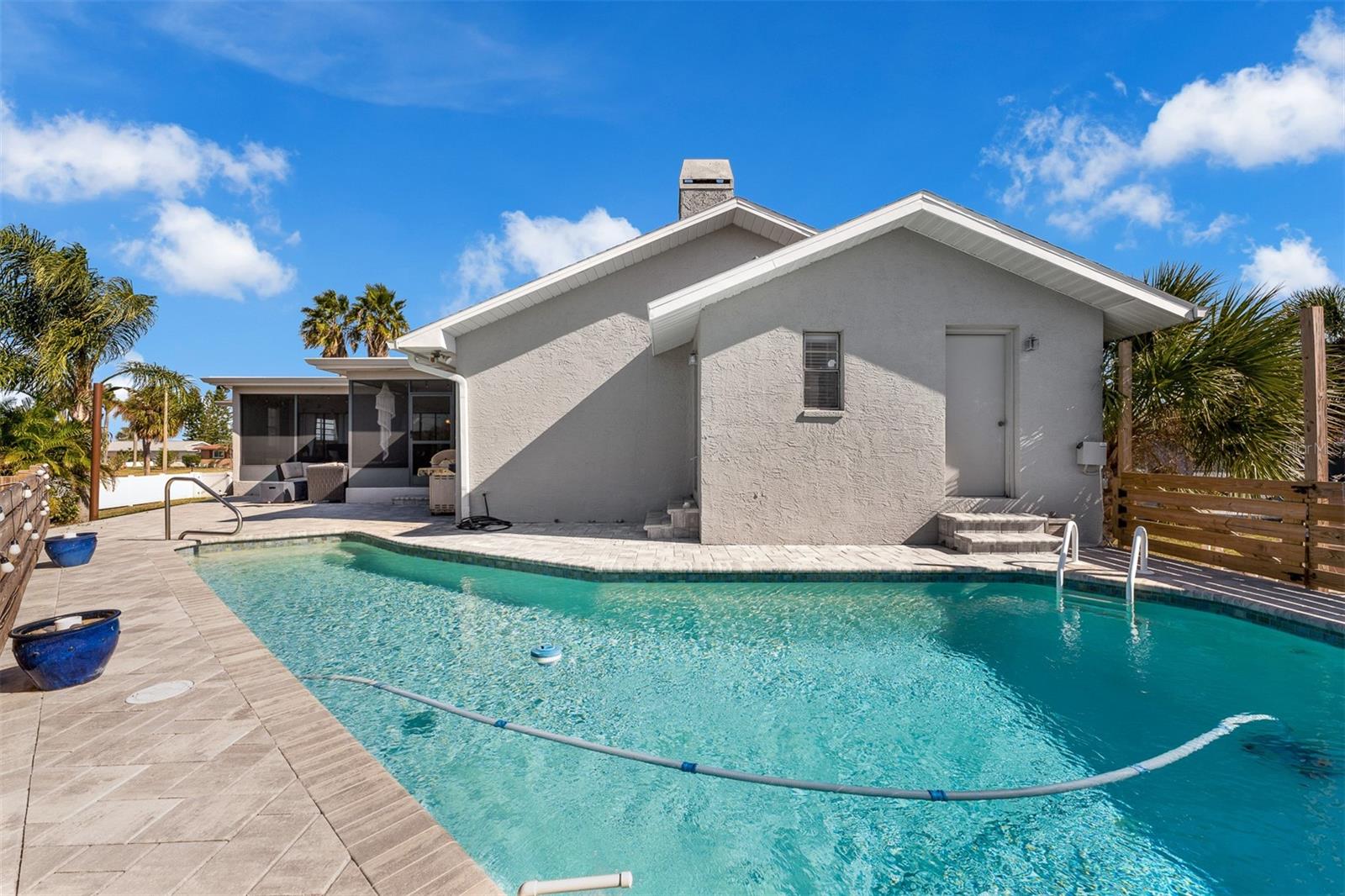 View of end of home. Pool storage room on back side.  Pool bath with window located off the bedroom #4.