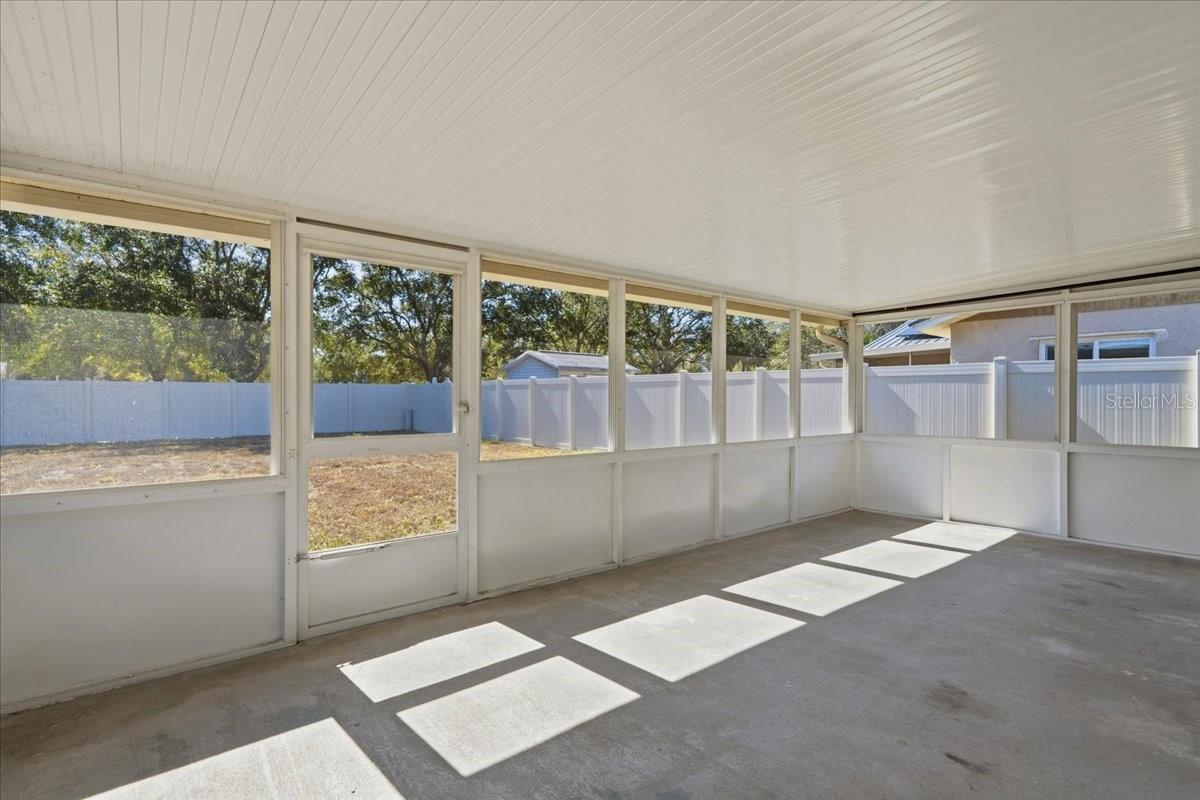 A spacious 22x12 screened-in patio opens to a large, fully fenced backyard that backs up to Helen S. Howarth Community Park and features a private gated entrance for direct access.