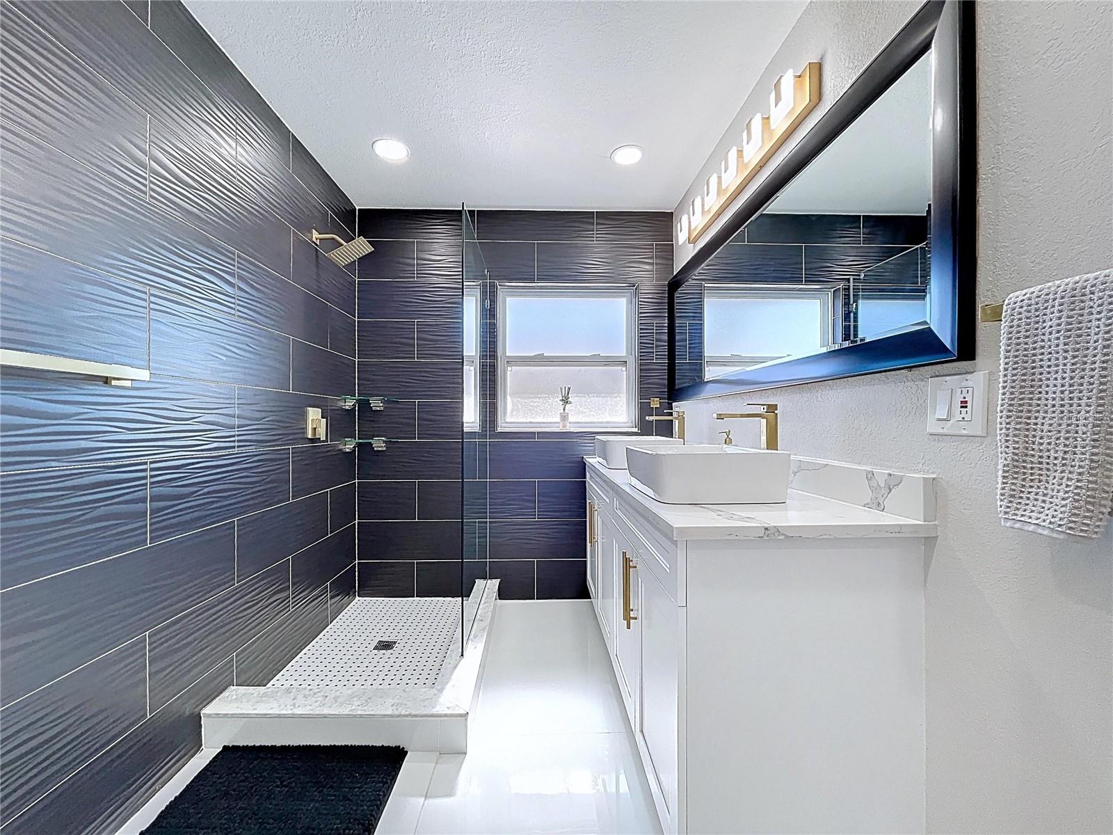Textured tile walls w/ glass walk in shower