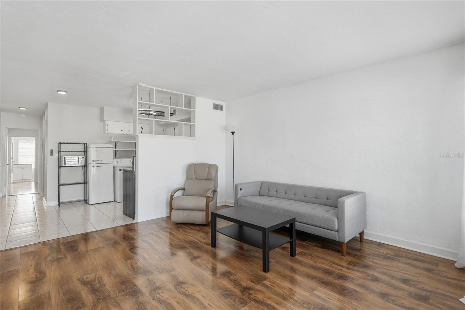 Tons of natural light shows off the warm laminate flooring in this ample living space