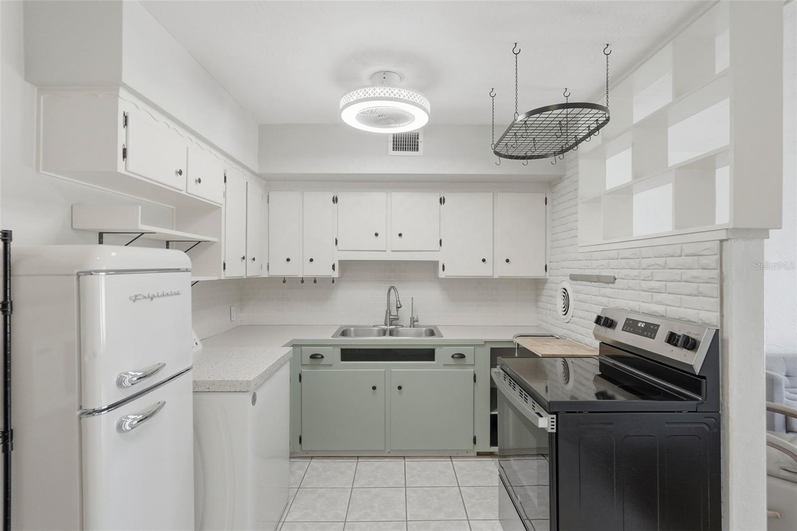 Charming kitchen with adorable ceiling fan, pot rack, and newer appliances