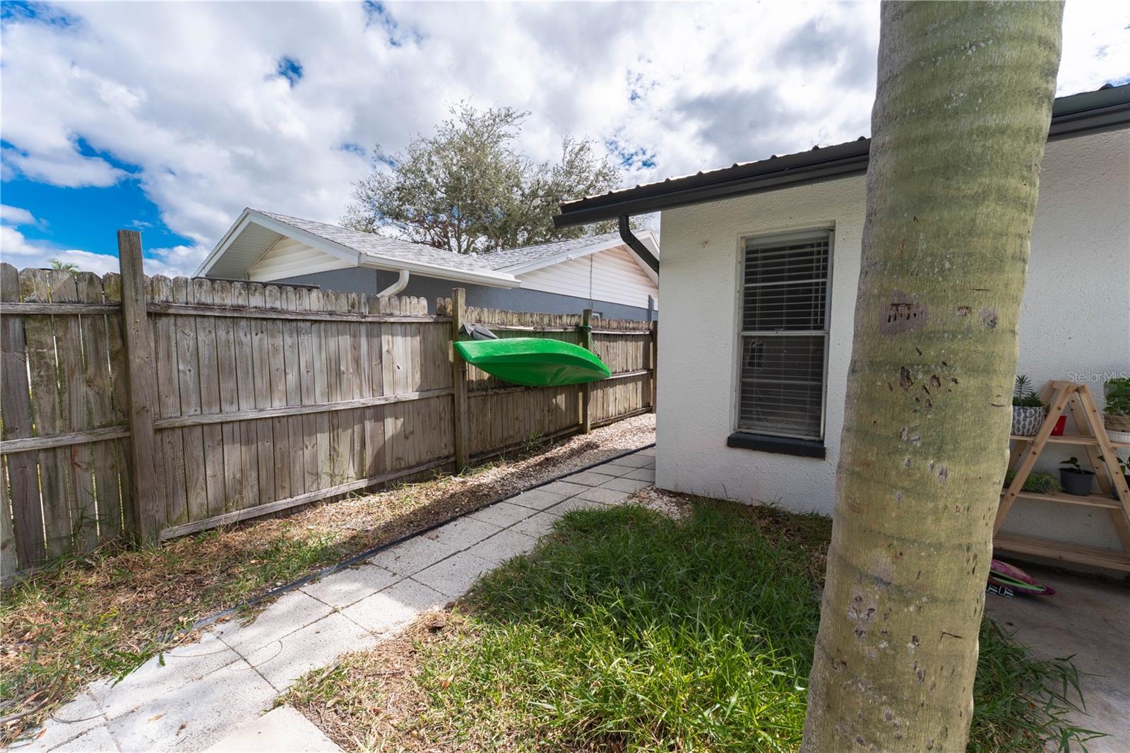 Side yard with access to pool area, offers a separate play/run space.