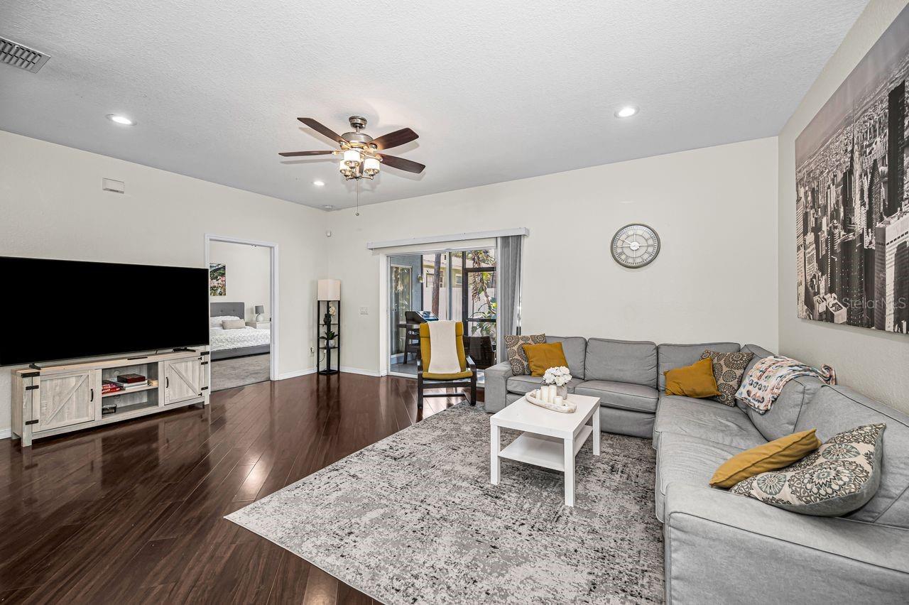 Living room looking into primary suite and the screened-in patio