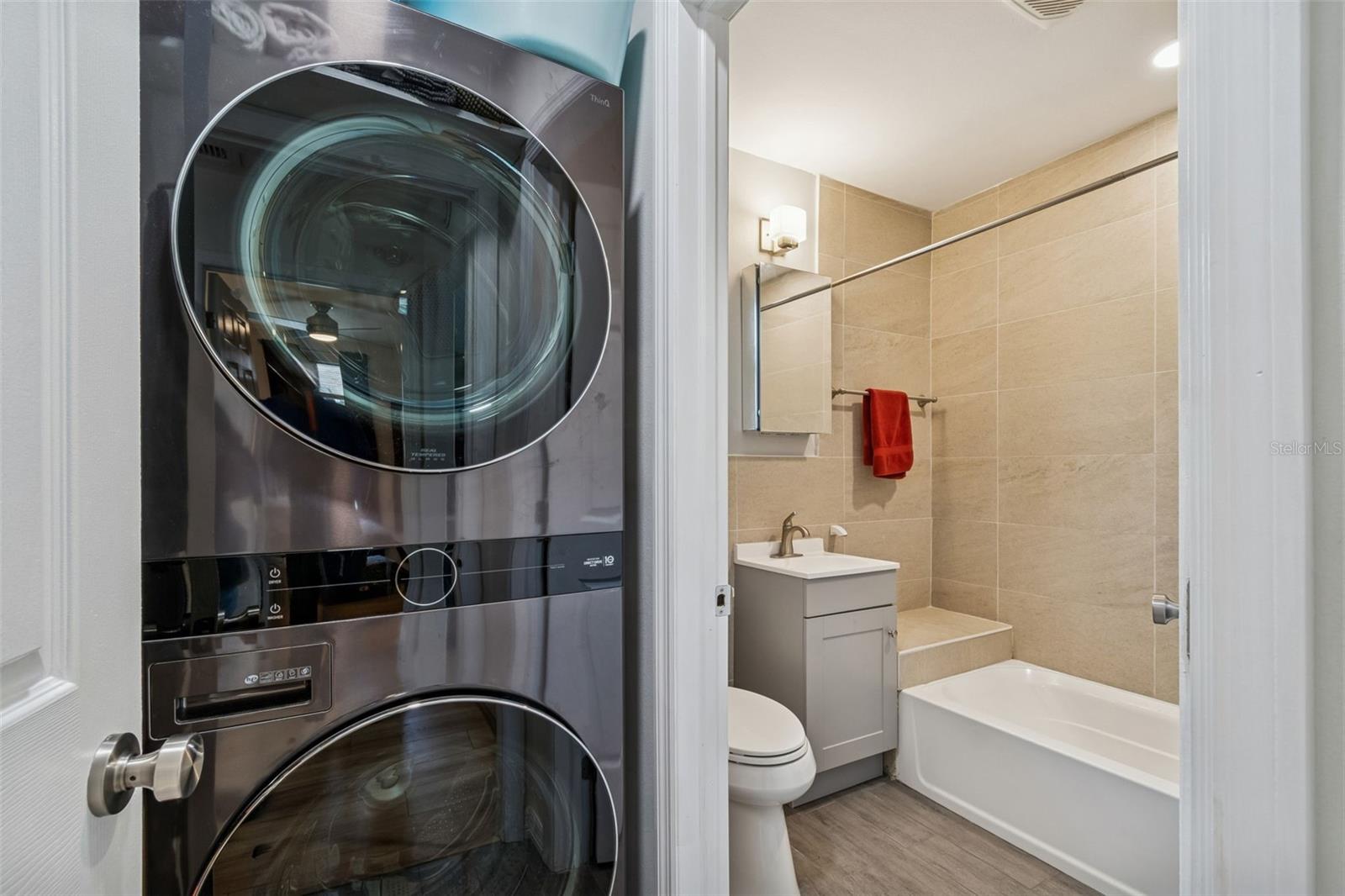 Stacked washer/dryer near entrance to guest bath