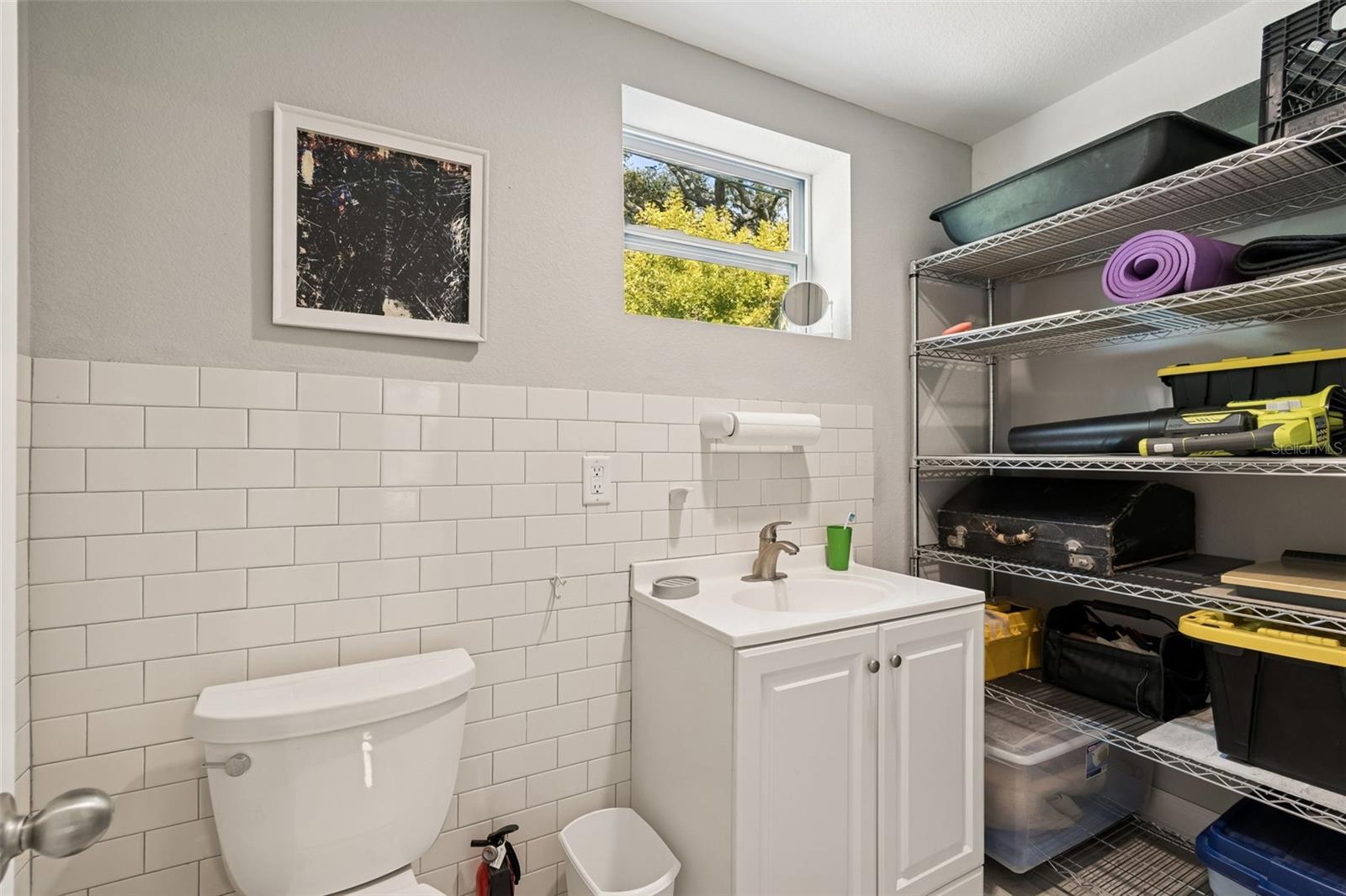 Half bath in back of Studio. Rough plumbing for a shower is behind the shelves