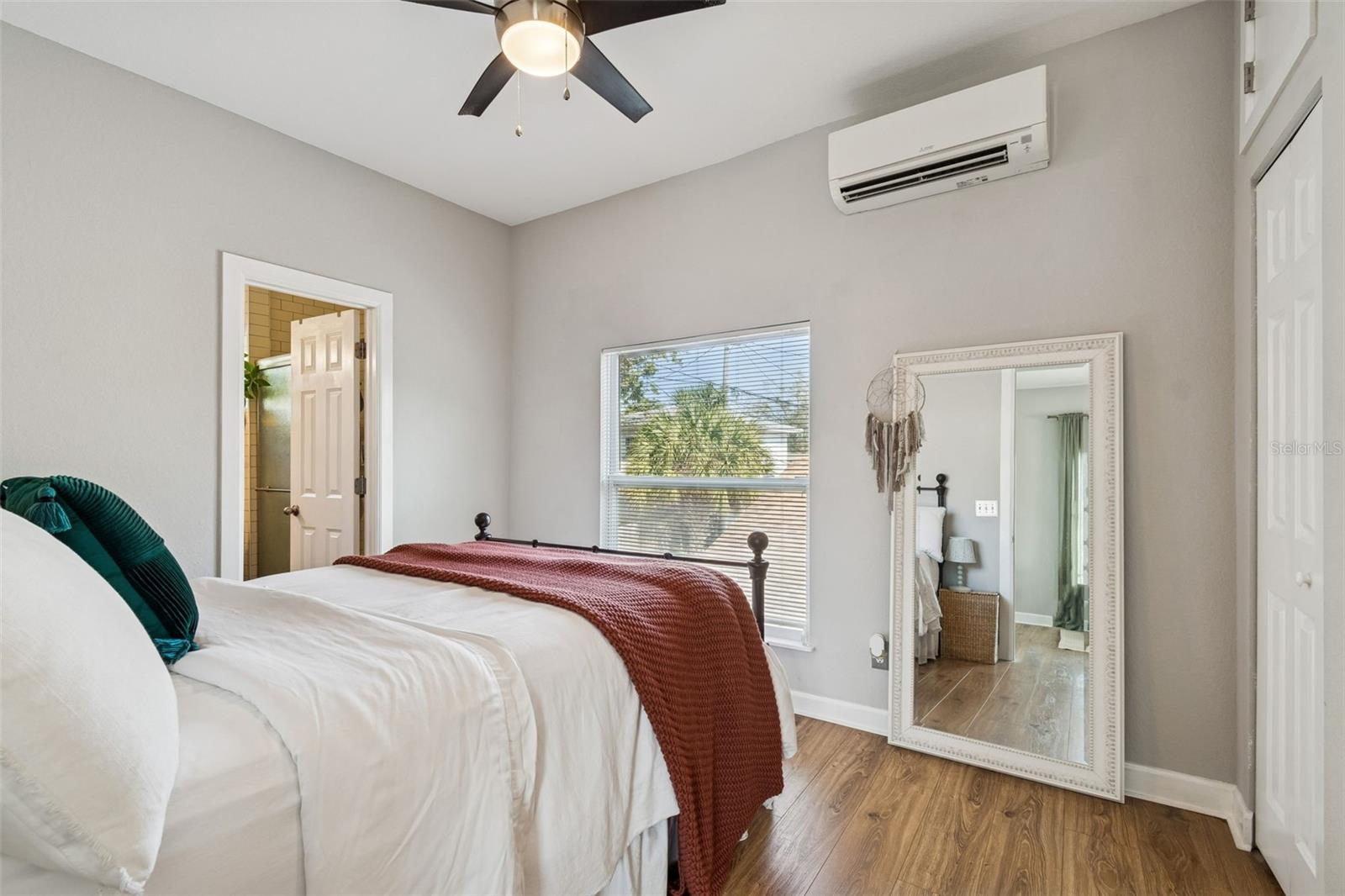 Apartment bedroom. Note the large window and split system cooling unit