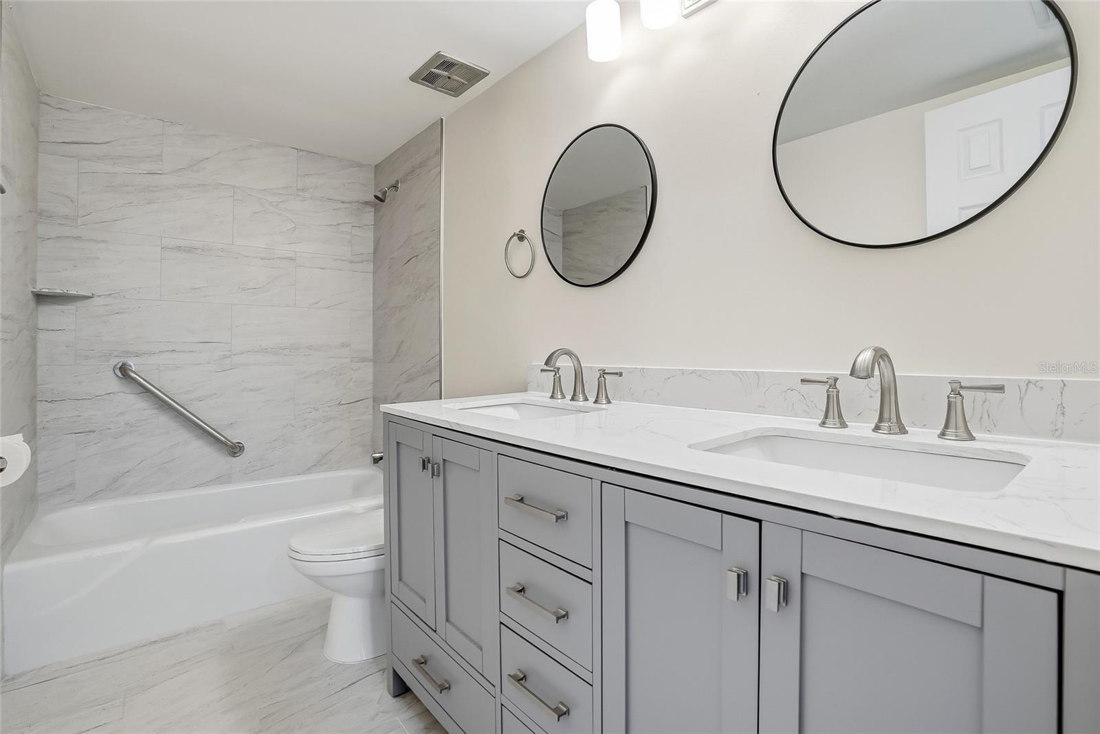 Primary Bath has dual sinks and a soaking bath tub with easy grab handle.