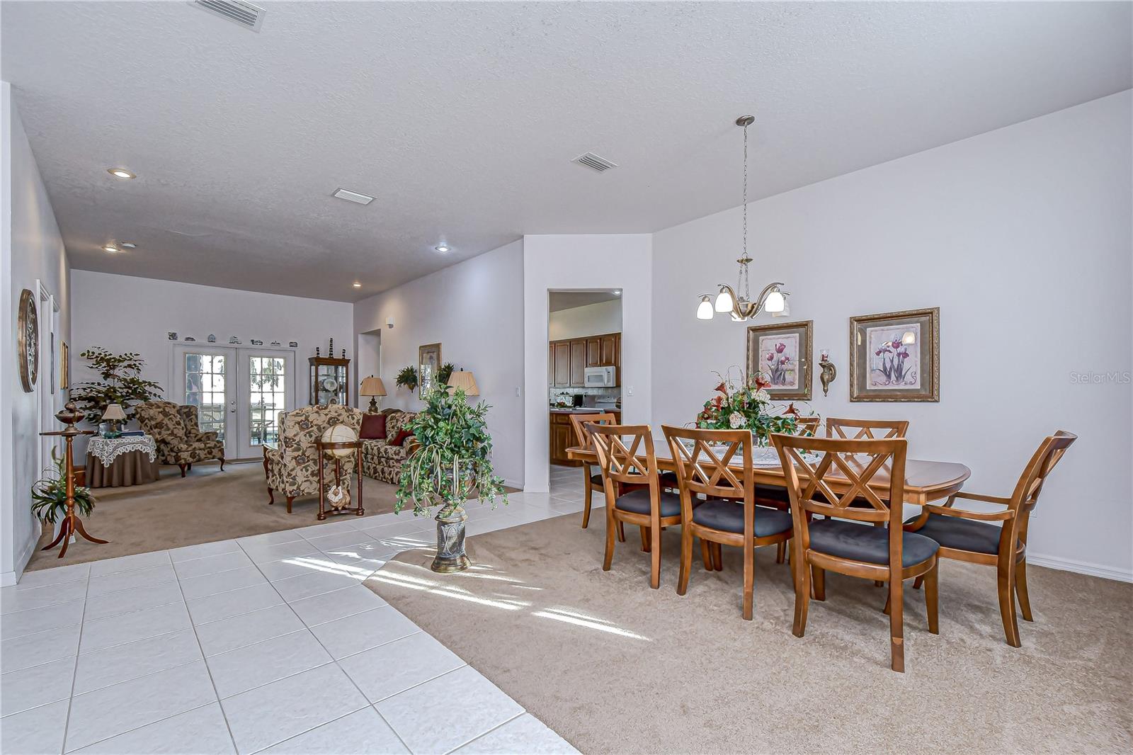 Open dining and living area with bright tile floors, and French doors to the patio!