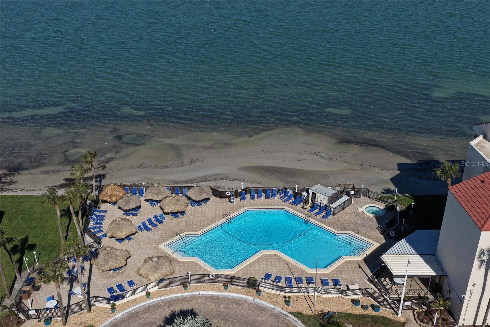 Aerial view of the waterfront pool and sundeck. Plus hot tub and grilling area.