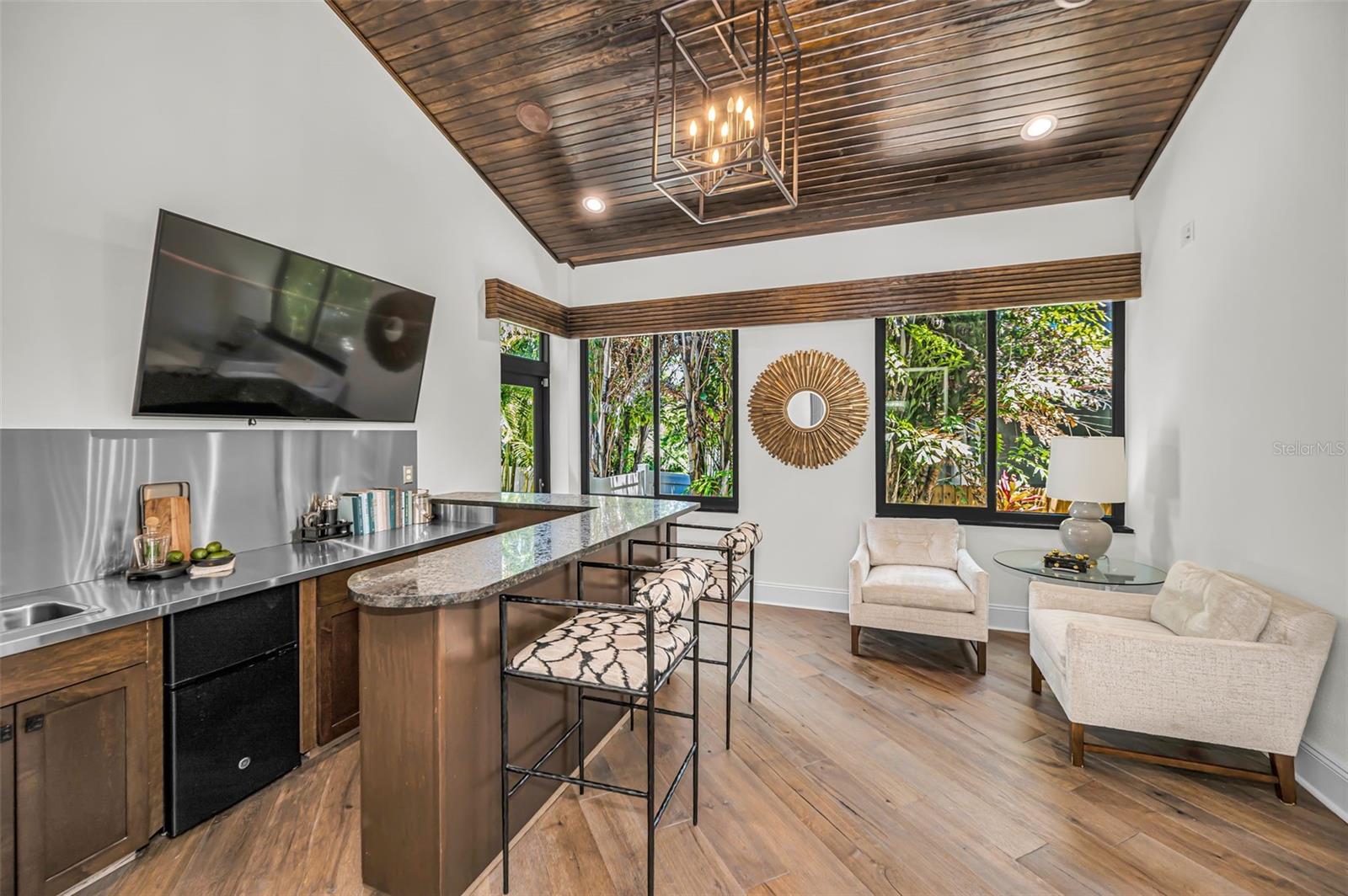 A striking indoor wet bar with high ceiling and gorgeous wood detailing.