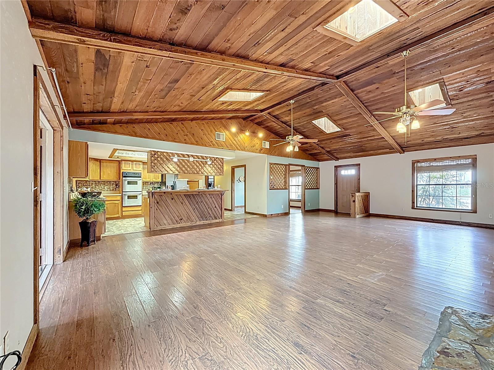 Cathedral cedar wood ceiling, working fireplace (wood converted to gas) 30'4" x 21'9" and open floor plan with 4 seat breakfast bar open kitchen and enclosed family room