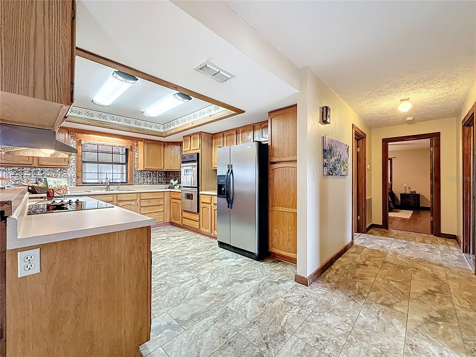 Open kitchen design with breakfast bar, cook top, RO water system, dishwasher, fridge and double oven