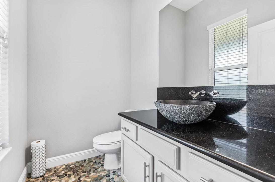 half bath stone counters and stone floor