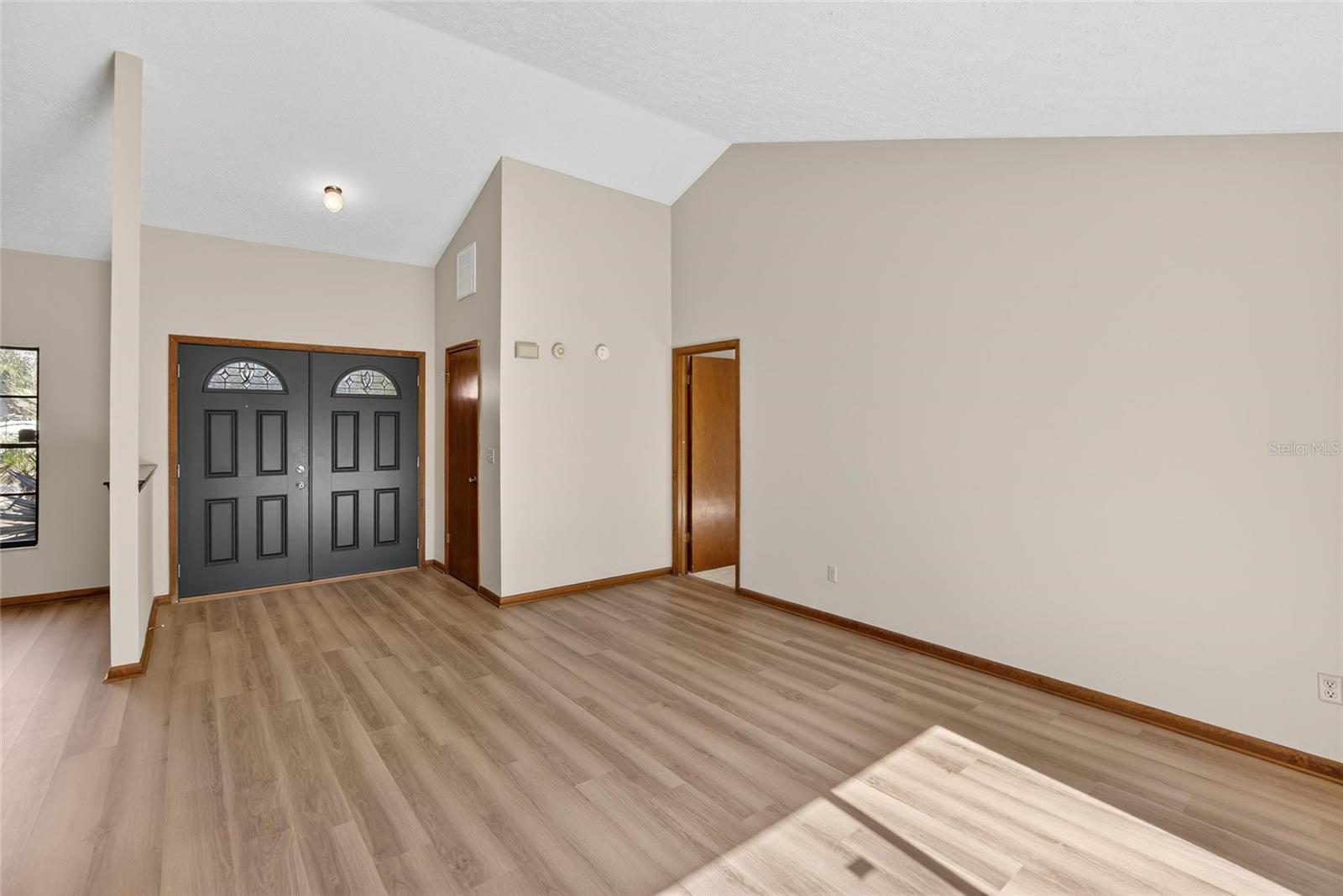 View of Foyer from Living Room.  Door to Primary Suite to the Right