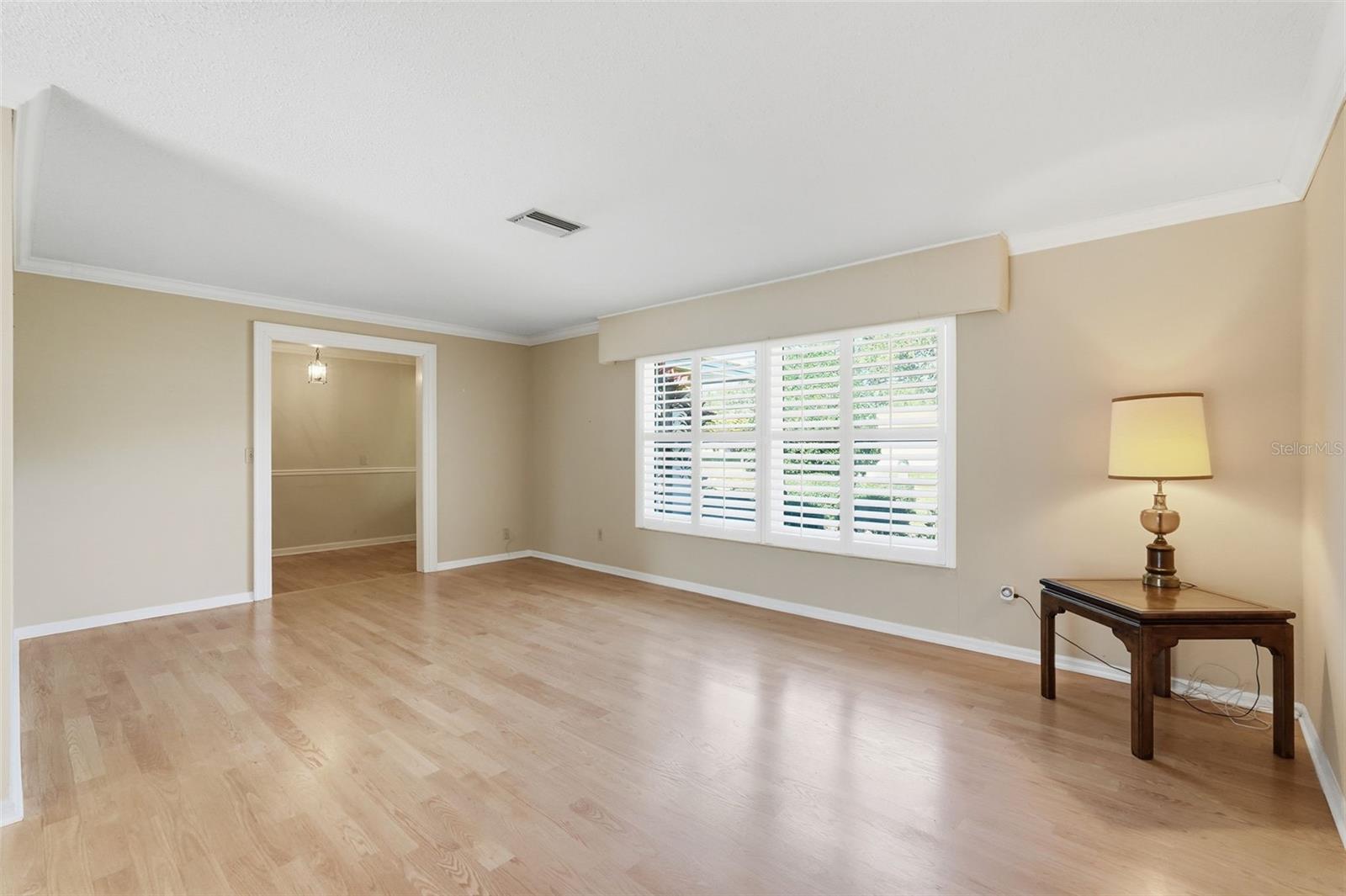 Wood Floors Living Room with Plantation Shutters and Impact Windows