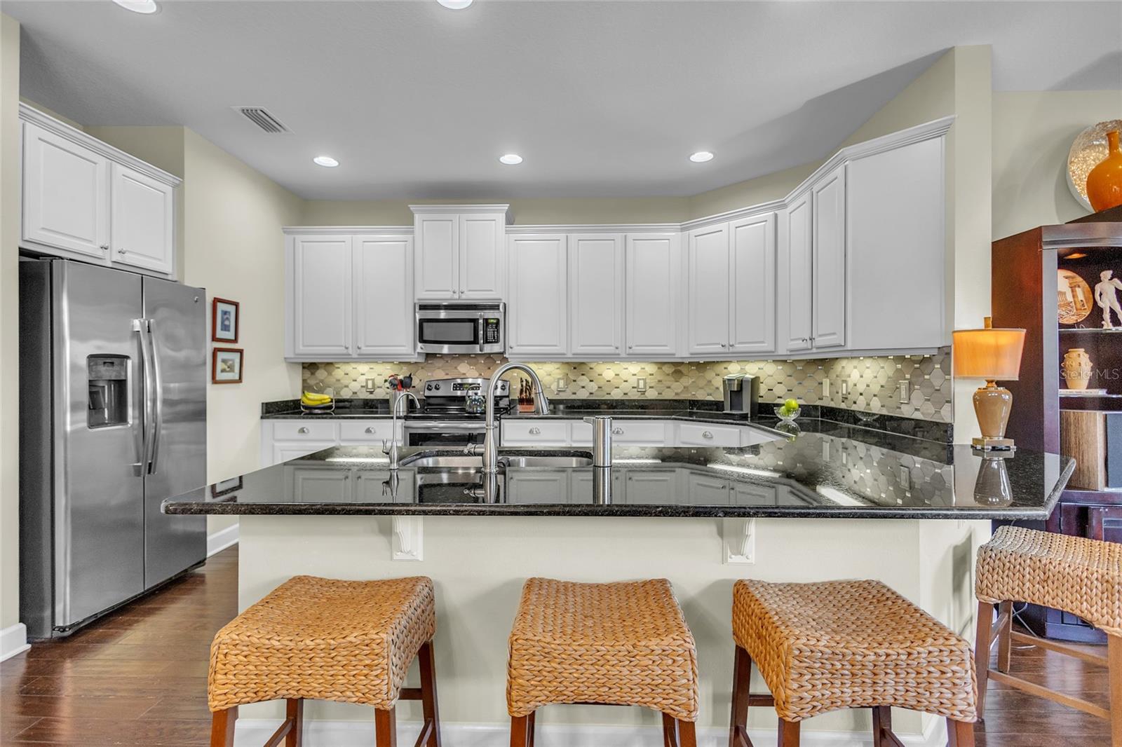 Beautiful and highly functional U-shaped Kitchen offers great prep space and causal dining. Owner added separate water filtration dispenser. Whole house water softener keeps dishes from spotting aiding the new dishwasher.